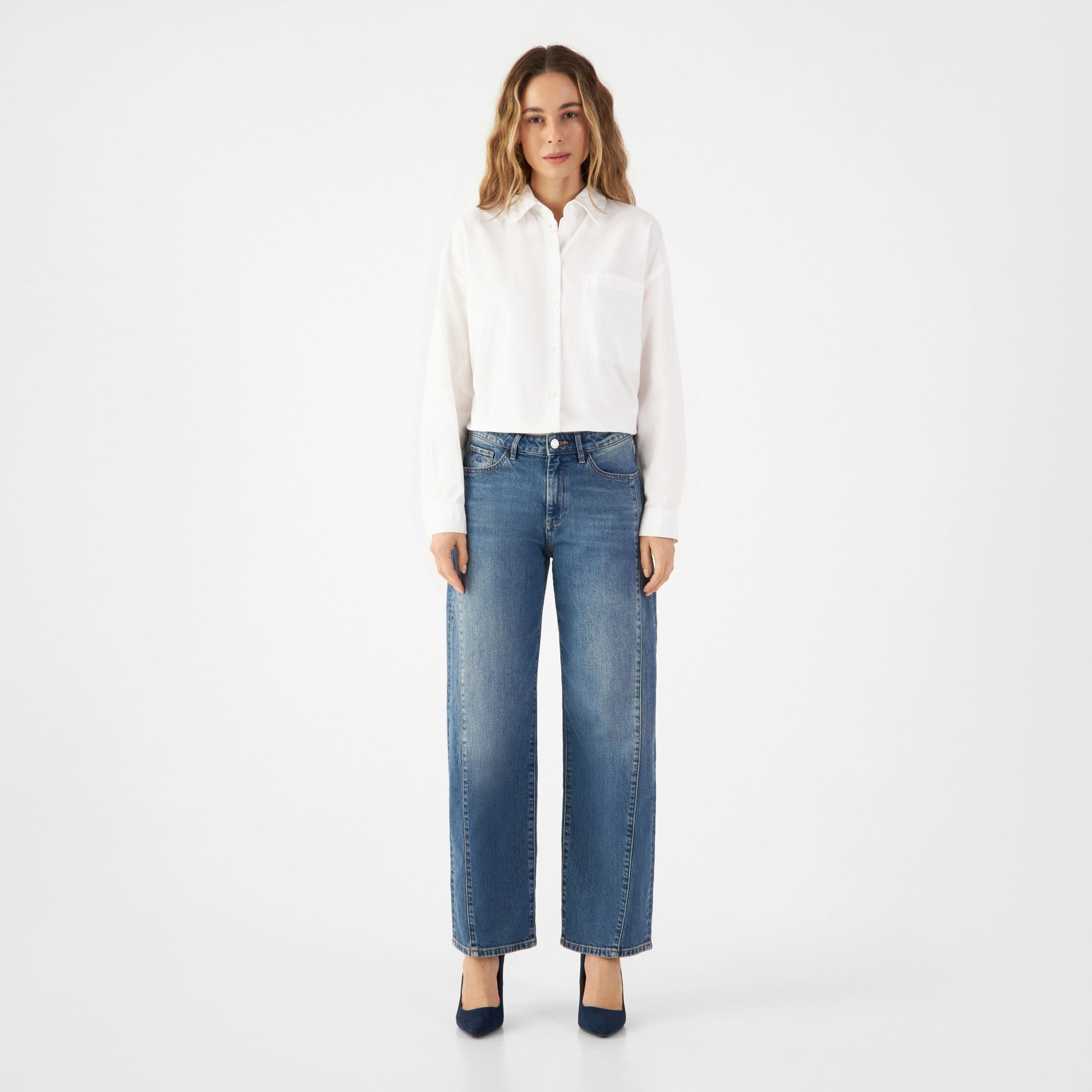 Vintage Blue ASH Barrel-Leg Jeans von DAWN, mittelhohe Taille, weite Oberschenkel, schmaler Saum; getragen von einer Person in weißem Hemd.