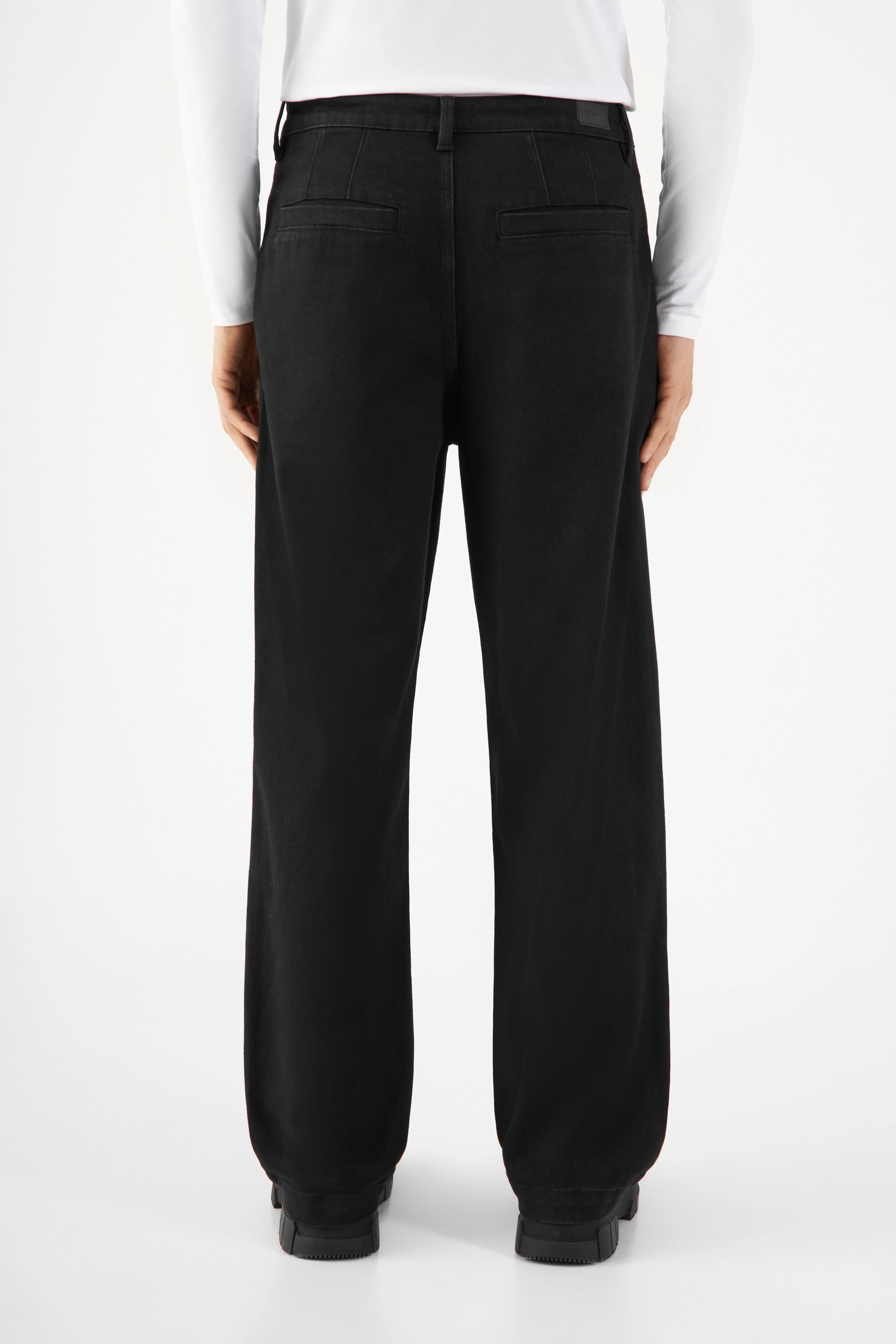 Rückansicht der schwarzen ASTER Balloon-Fit Hose aus Tencel-Denim, mittelhoher Bund, weite Hüften und Oberschenkel, zum Saum hin schmaler, zwei hintere Paspel-Taschen.