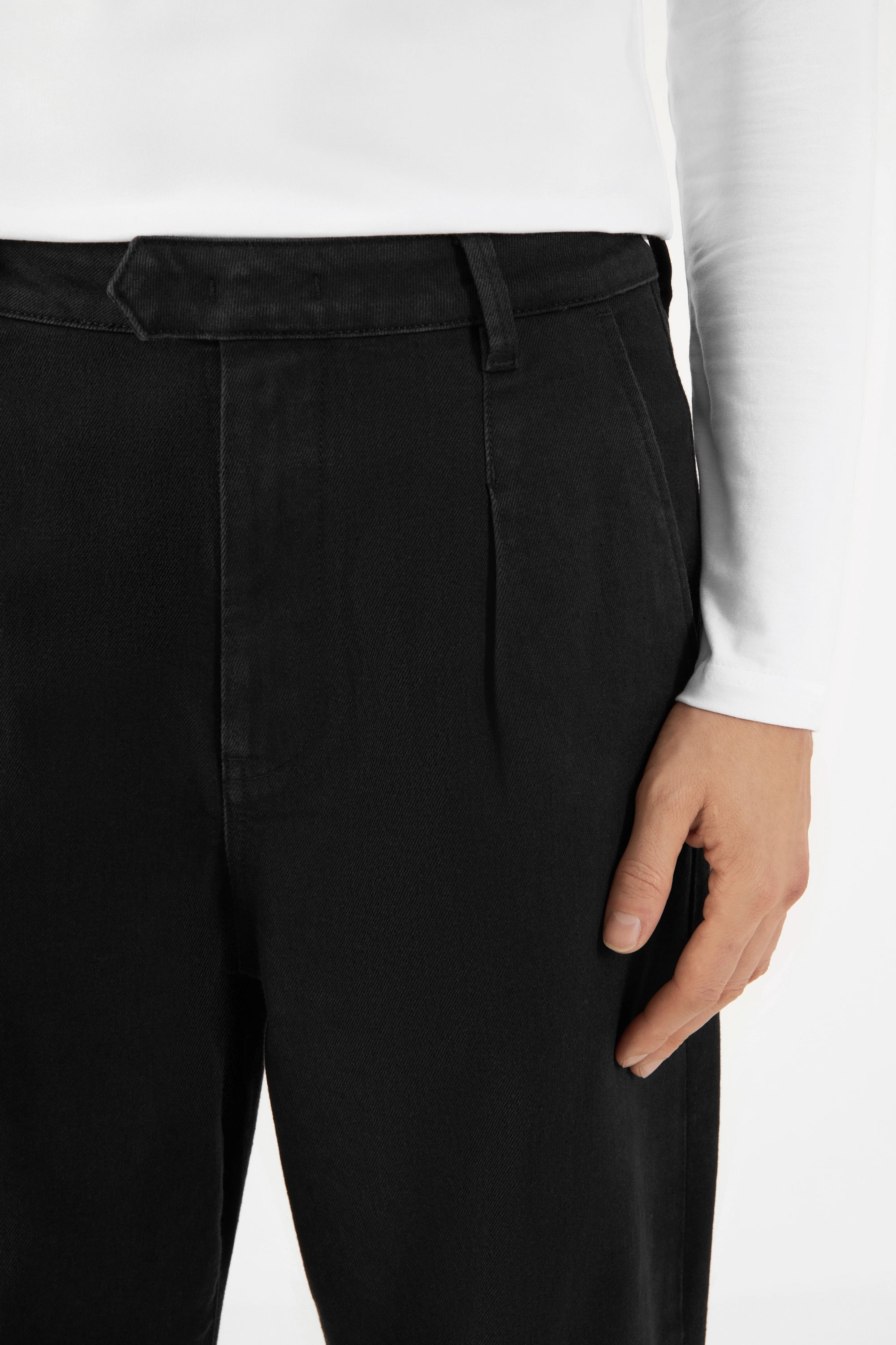 Schwarze Balloon-Fit Hose aus TENCEL-Denim, mittelhoher Bund; weite Hüften/Oberschenkel, wird zum Saum hin schmaler, Gürtel-Schlaufe sichtbar.