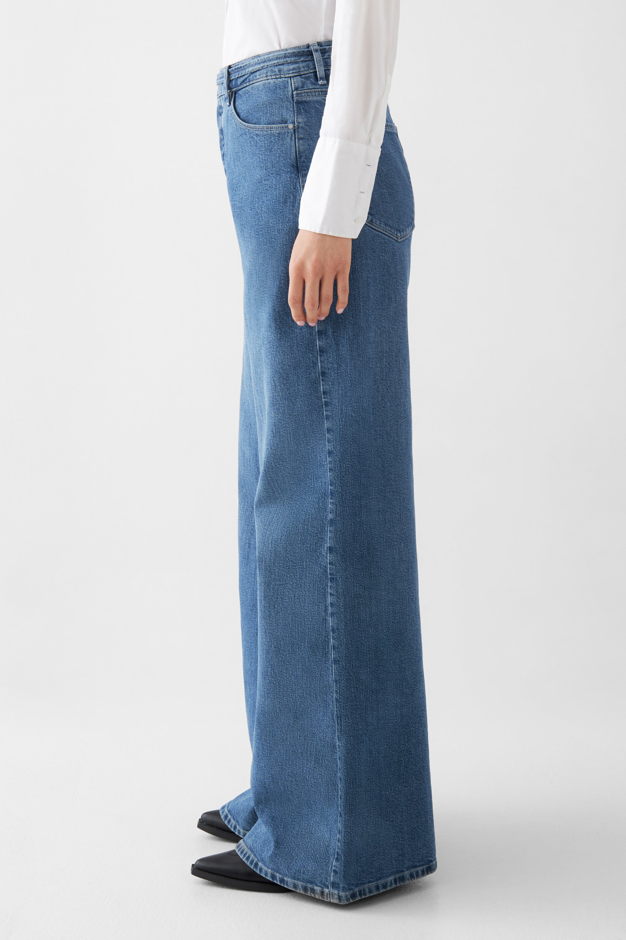 BLAZE High Waist – Super Wide Leg Jeans in Medium Blue, seitliche Ansicht einer 5-Pocket-Jeans mit weißem Hemd, hohe Taille und weites Bein.