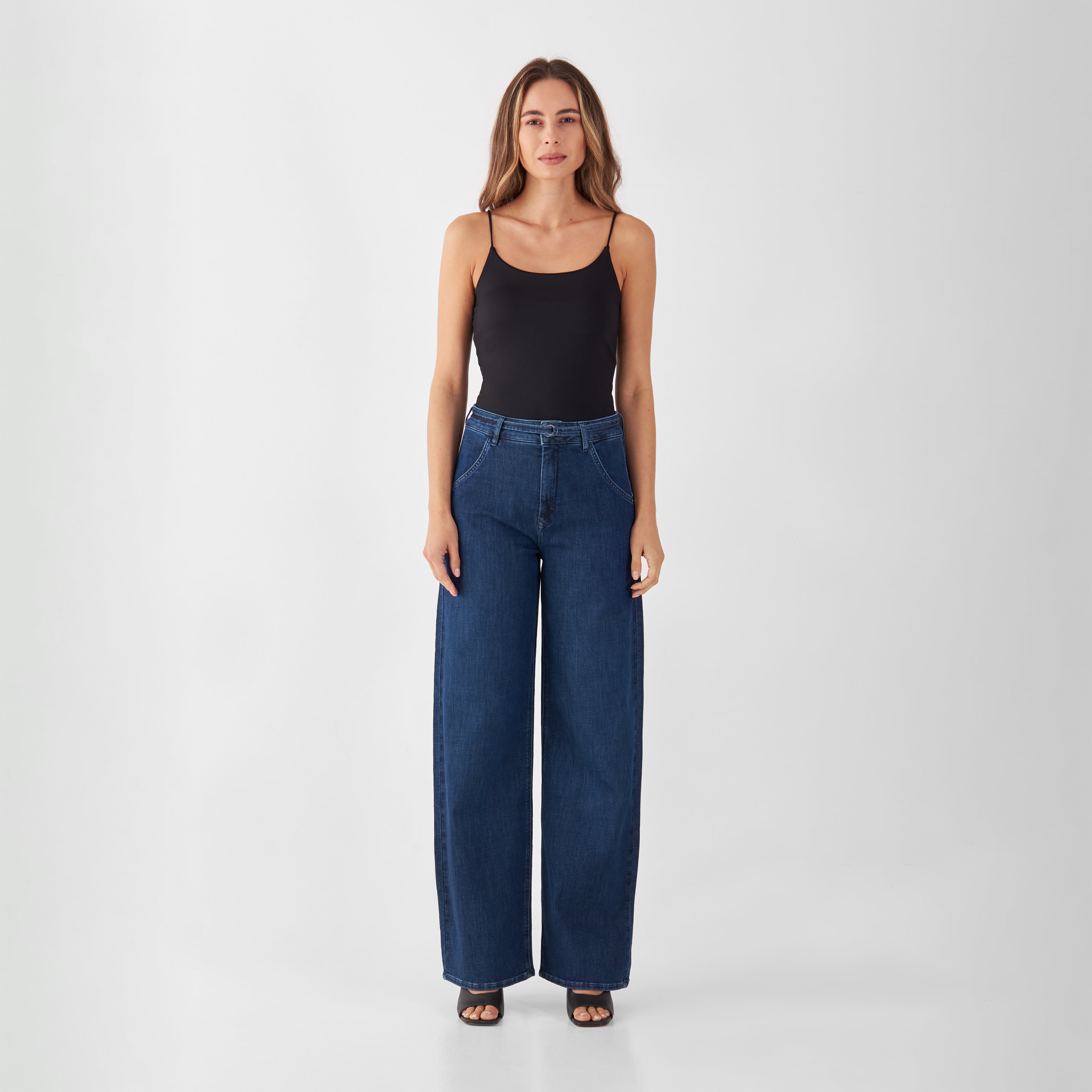 Modell trägt dunkelblaue BLINK High-Waist-Wide-Jeans: hohe Taille, weites Bein, entspannt an der Hüfte, kombiniert mit schwarzem Top.