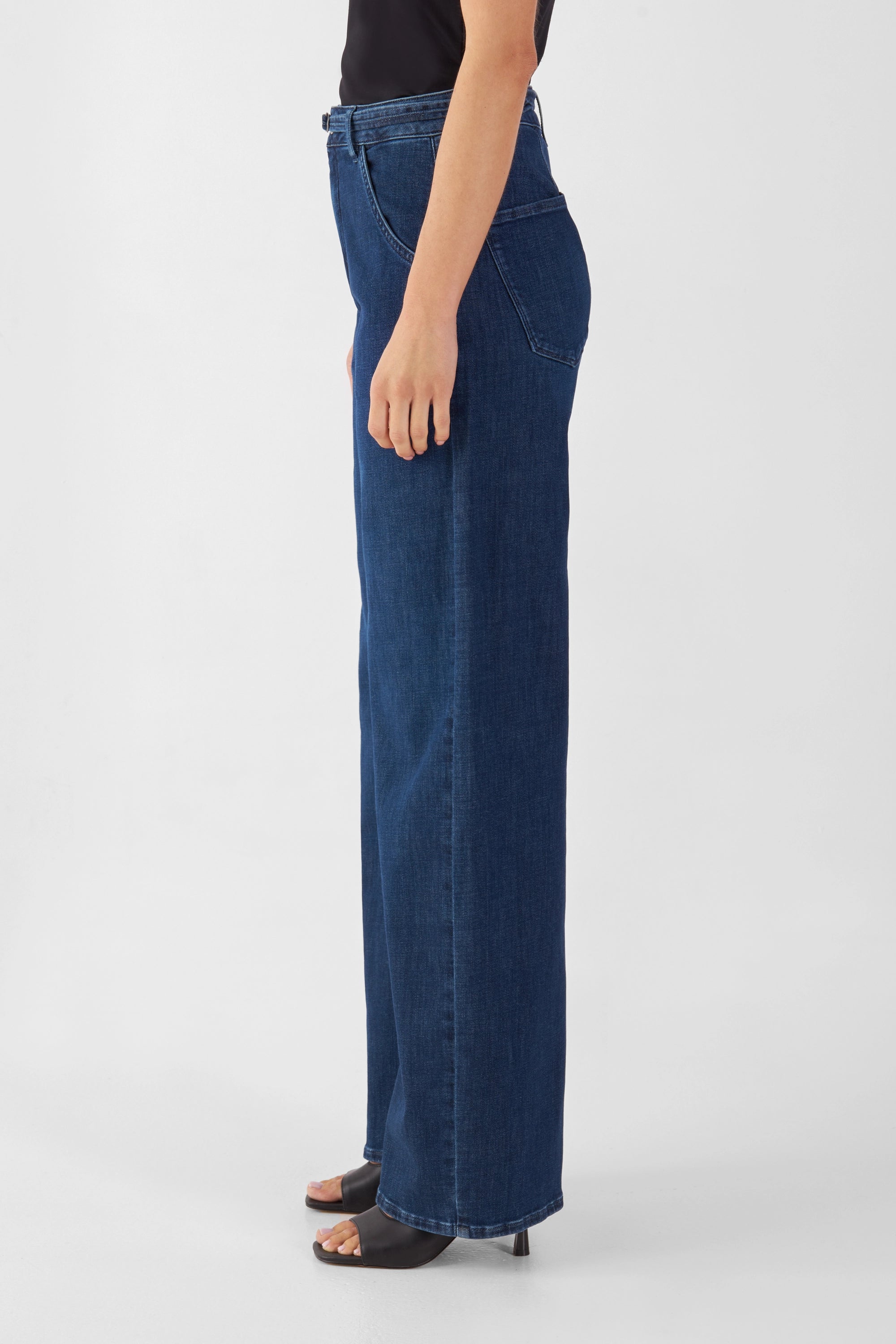Seitenansicht einer dunkelblauen High-Waist-Jeans mit weiterem, geradem Beinverlauf.