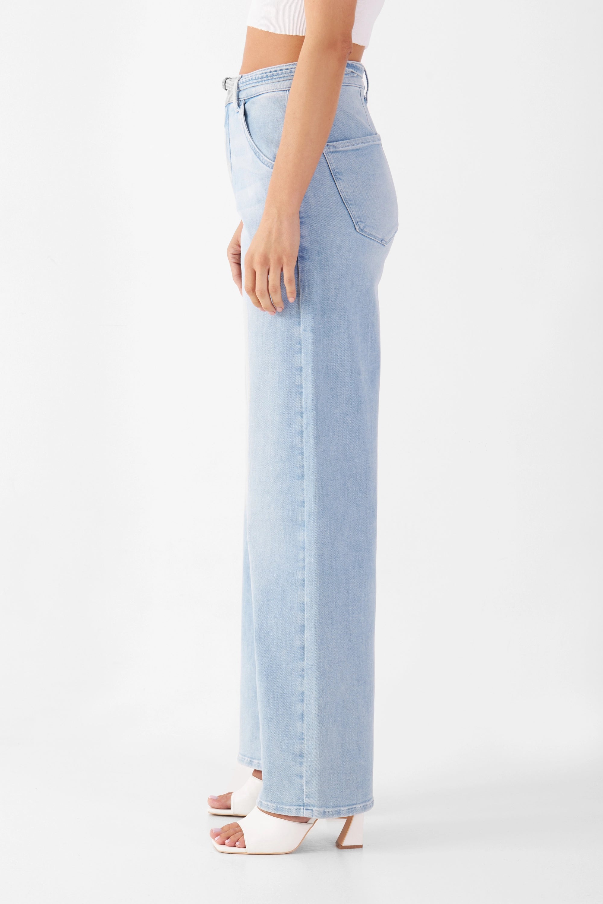 Seitliche Ansicht einer hellblauen BLINK High Waist Wide Jeans mit hohem Bund und weiterem geraden Beinverlauf; Model trägt weißen Top.