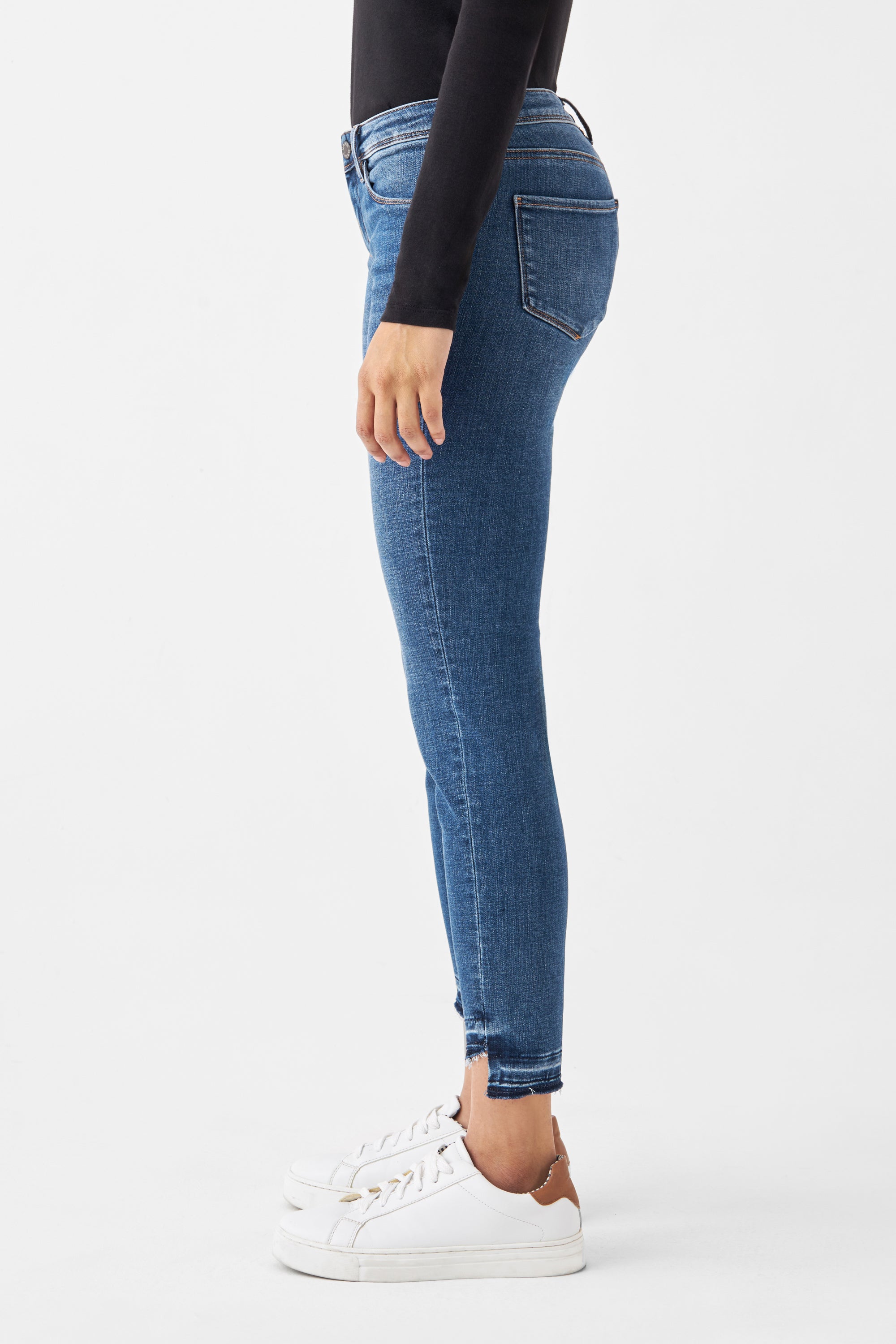 Medium Blue MID SUN Slim-Fit Jeans mit Comfortstretch, offener fransiger Saum; Seitenansicht eines Modells in schwarzem Oberteil und weißen Sneakern.