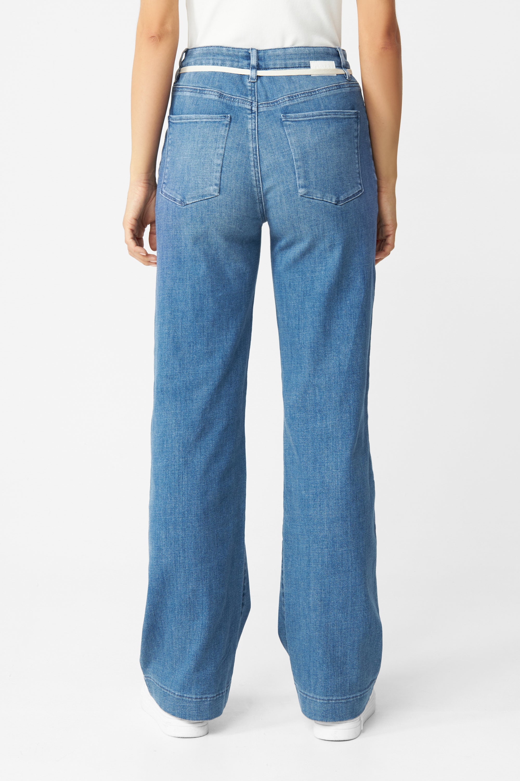 Rückansicht: DEW Flared Soft Denim Jeans in Medium Blue, hohe Taille, ausgestelltes Bein, französische Taschen, weißer Gürtel.