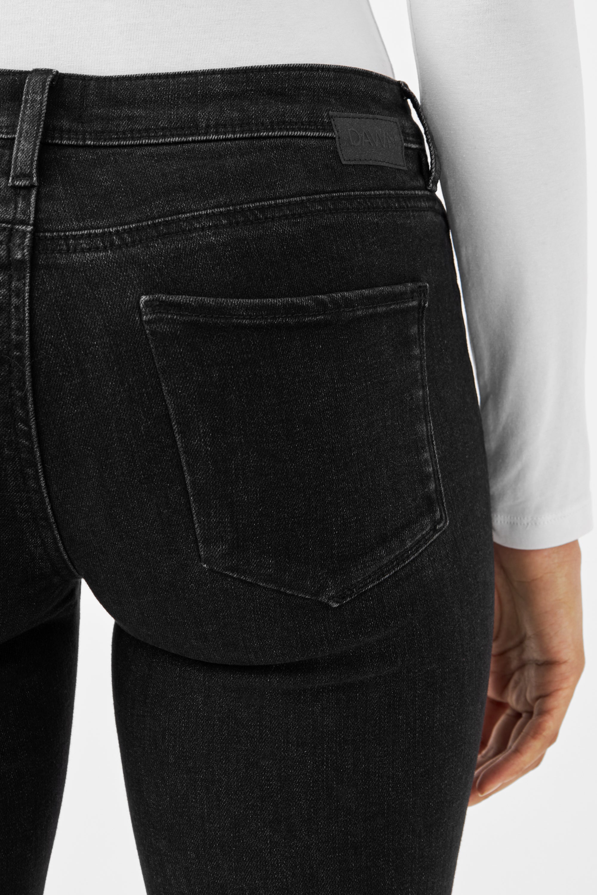 Rückansicht einer schwarzen Denim-Jeans von DAWN – MID SUN Slim Comfortstretch – mit Logo-Patch am Bund und sichtbarer Rückentasche.