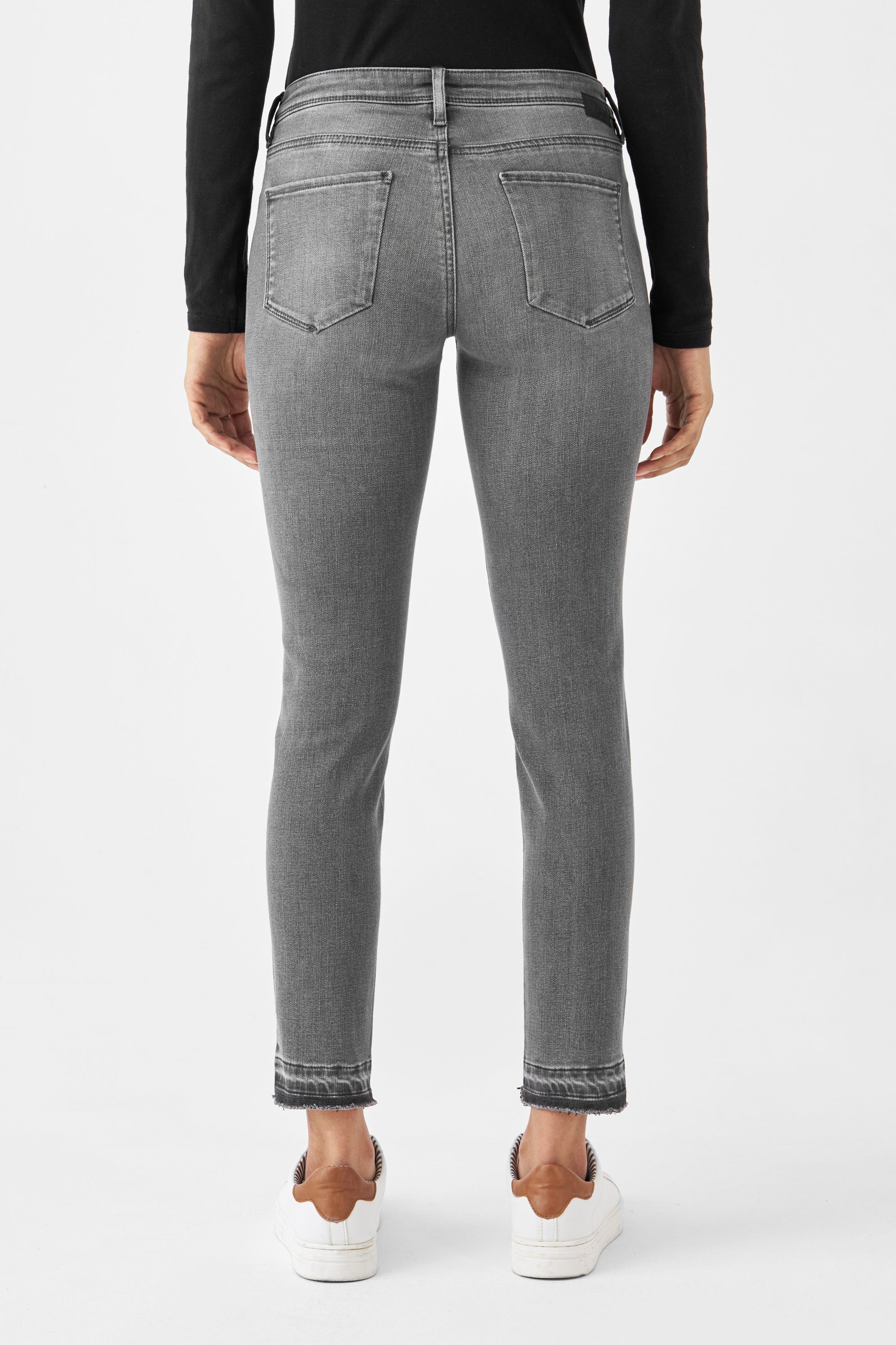 Rückansicht der MID SUN Slim Comfortstretch Jeans in Medium Grey: Low-Waist, zwei Gesäßtaschen, offener Saum; weiße Sneaker.
