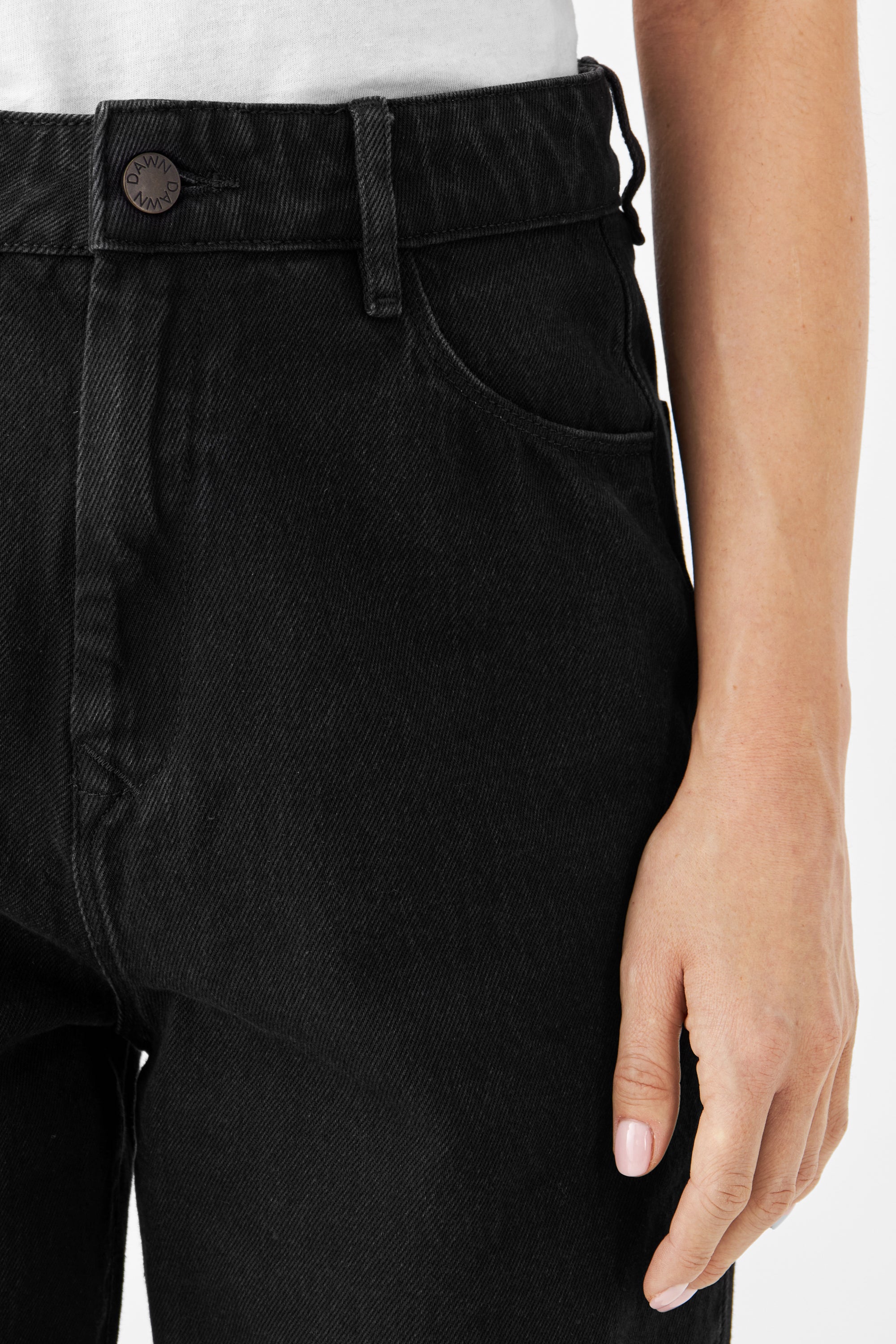 Schwarze DAWN Denim-Hose mit hoher Taille, weiter geradem Schnitt, cropped; Taillenpartie mit Knopf (DAWN-Logo) und vordere Tasche, aus festem Bio-Baumwoll-Denim.