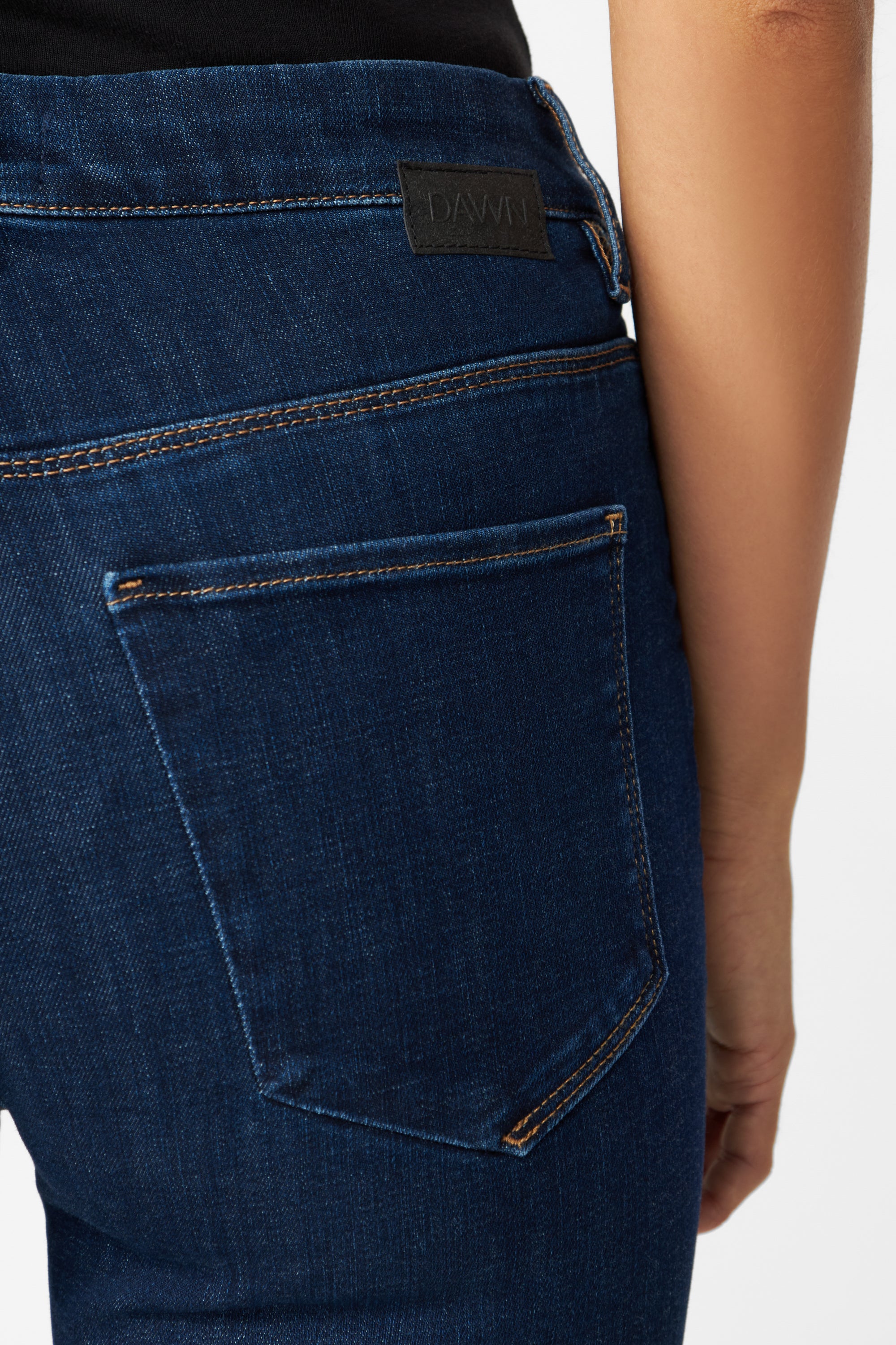 STELLAR Slim Comfortstretch – Classic in Dark Blue: Rückansicht einer High-Waist Denim-Jeans von DAWN mit Rückentasche, kontrastorange Nähten und DAWN-Label am Bund.