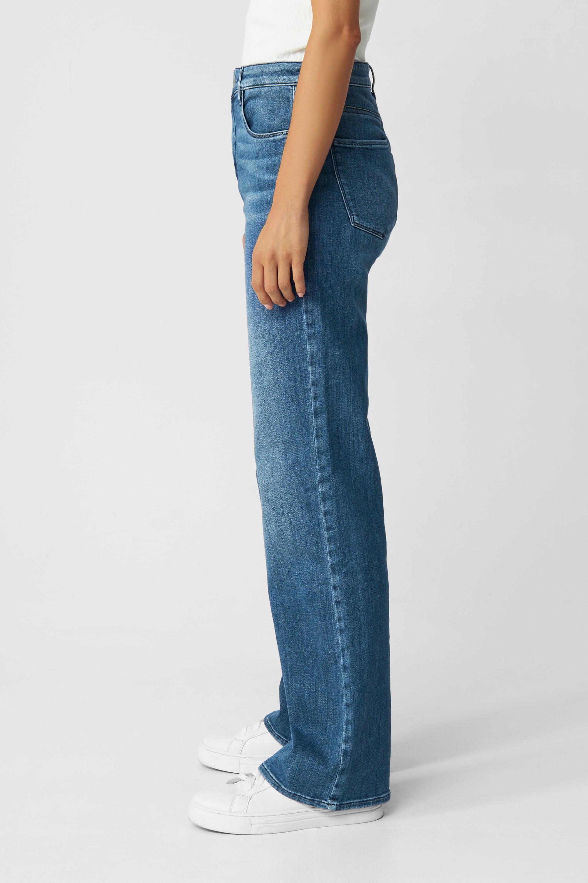 DEW Flared Soft Denim – Classic High-Waist Jeans in Medium Blue, seitliche Ansicht mit ausgestelltem Bein, Five-Pocket-Design und Stretch.