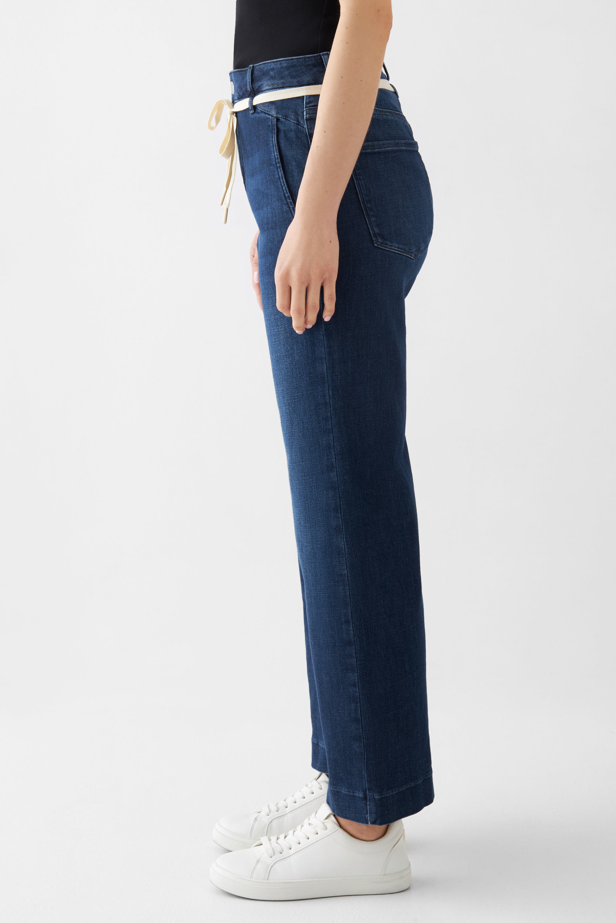 DEW Flared Cropped Jeans, dunkelblau, hohe Taille, ausgestelltes Bein – französische Taschen, Seitenansicht, hellbeiger Gürtel.