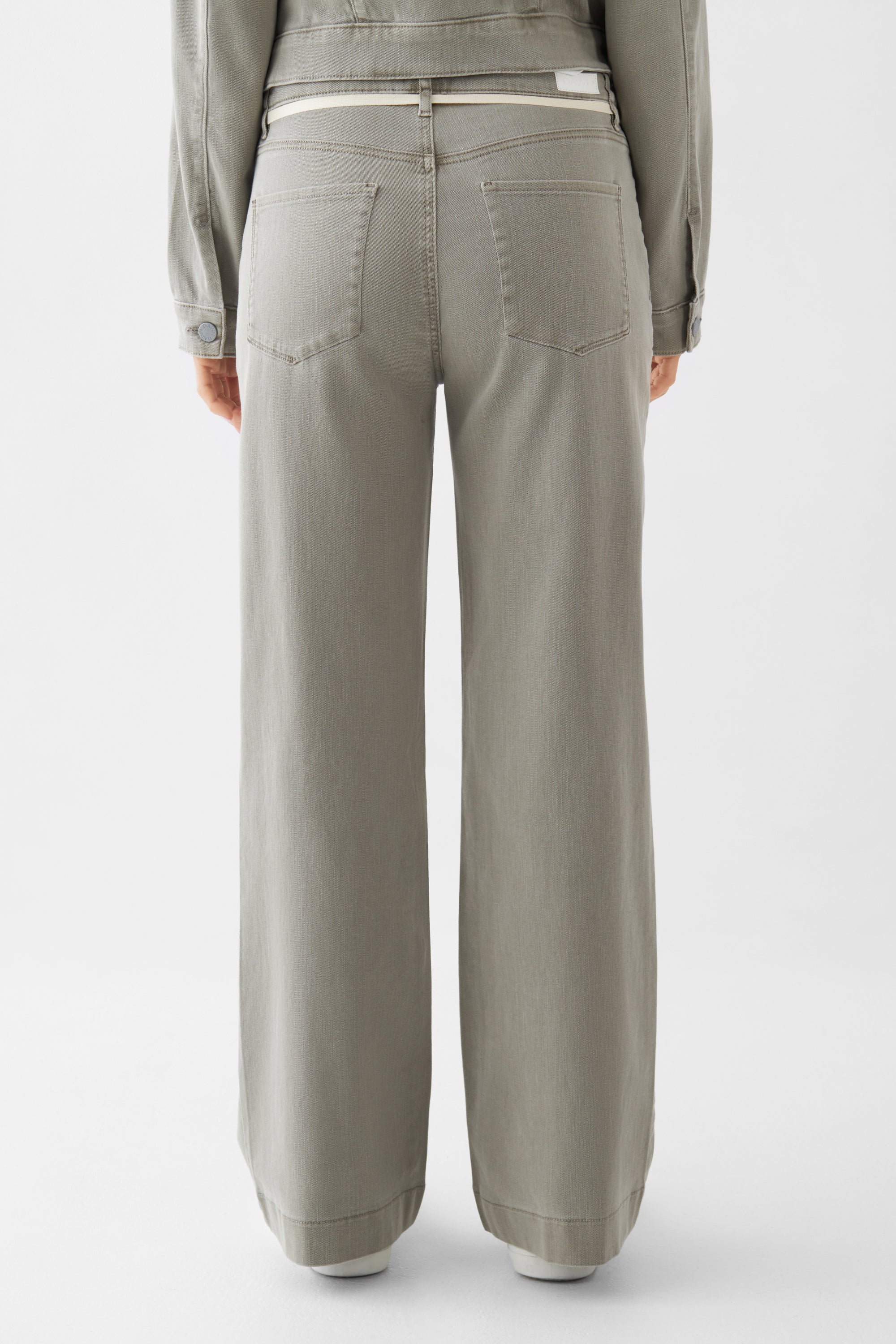 Rückansicht einer hoch taillierten, ausgestellten Flared-Jeans in Rock Olive mit zwei Gesäßtaschen aus Organic Soft Denim.