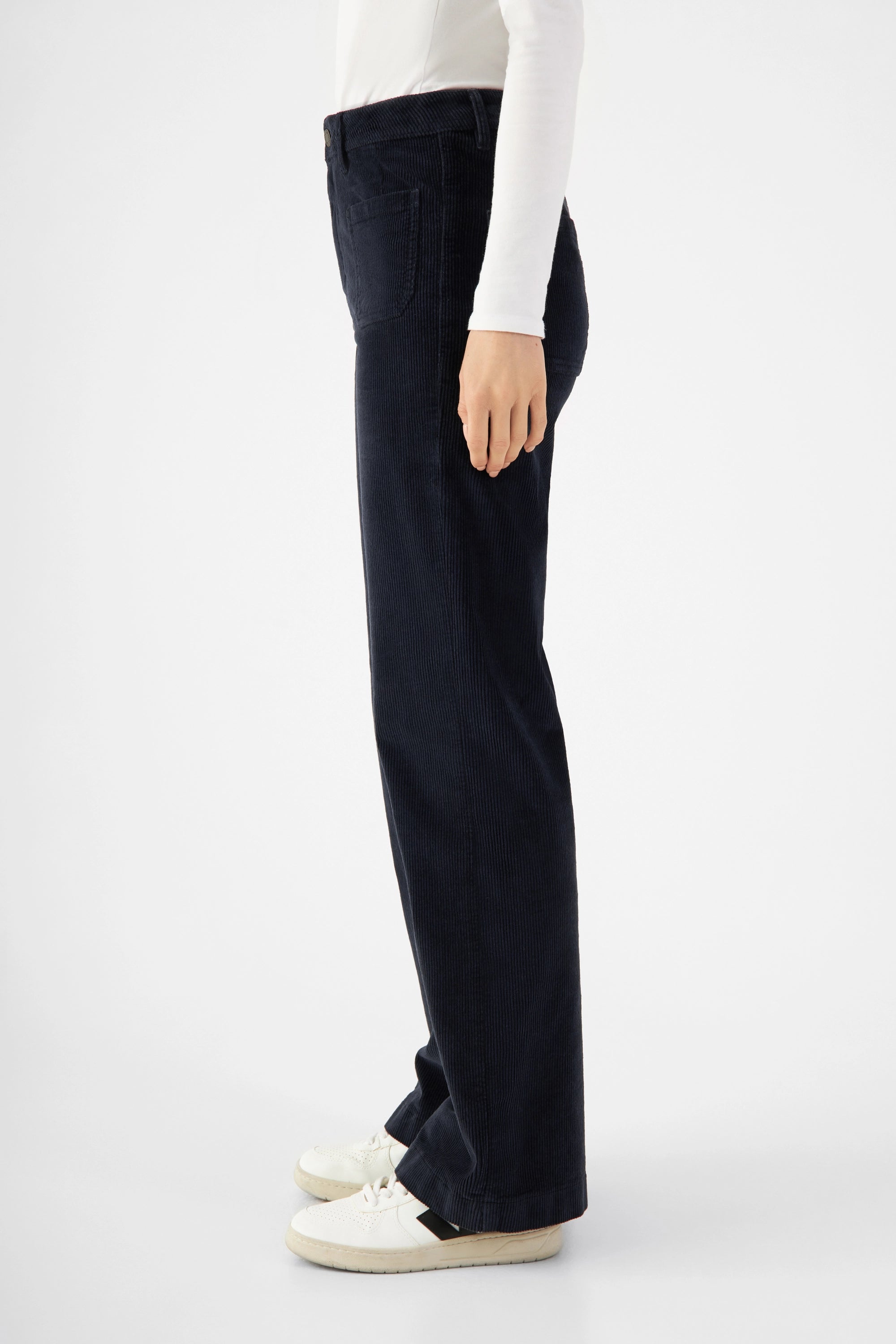DEW Sailor Flared Corduroy in Dark Navy: High‑Waist Hose mit weiterem Schnitt ab der Hüfte, vorn und hinten aufgesetzte Taschen; Organic Stretch Cord.