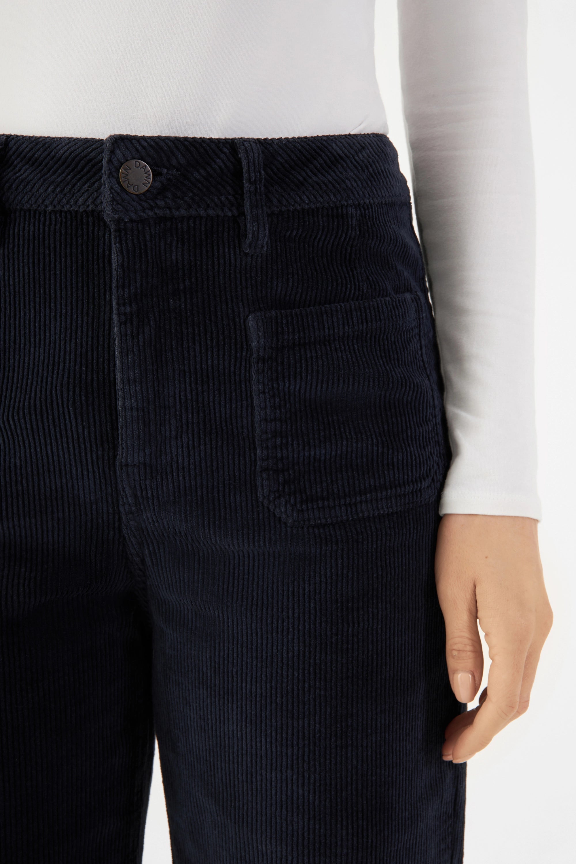 Dunkelblaue Corduroy-Sailor-Hose mit High-Waist und aufgesetzten Taschen vorne; Nahaufnahme Bund mit Knopf und Gürtel-Schlaufen.