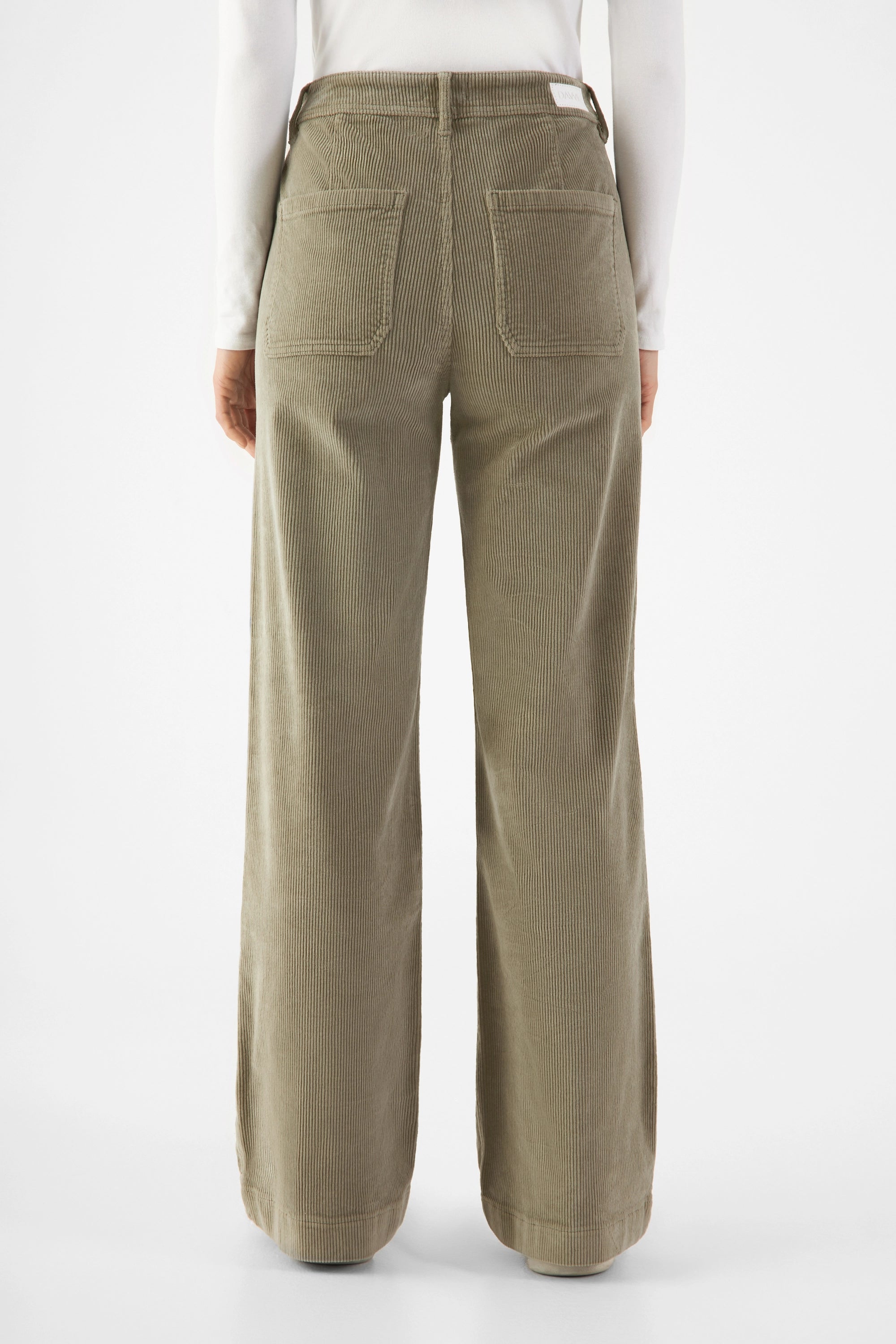 Sagegrüne Cordhose im Flared Fit mit hoher Taille, zwei aufgesetzte Gesäßtaschen; Rückansicht mit weitem Bein.