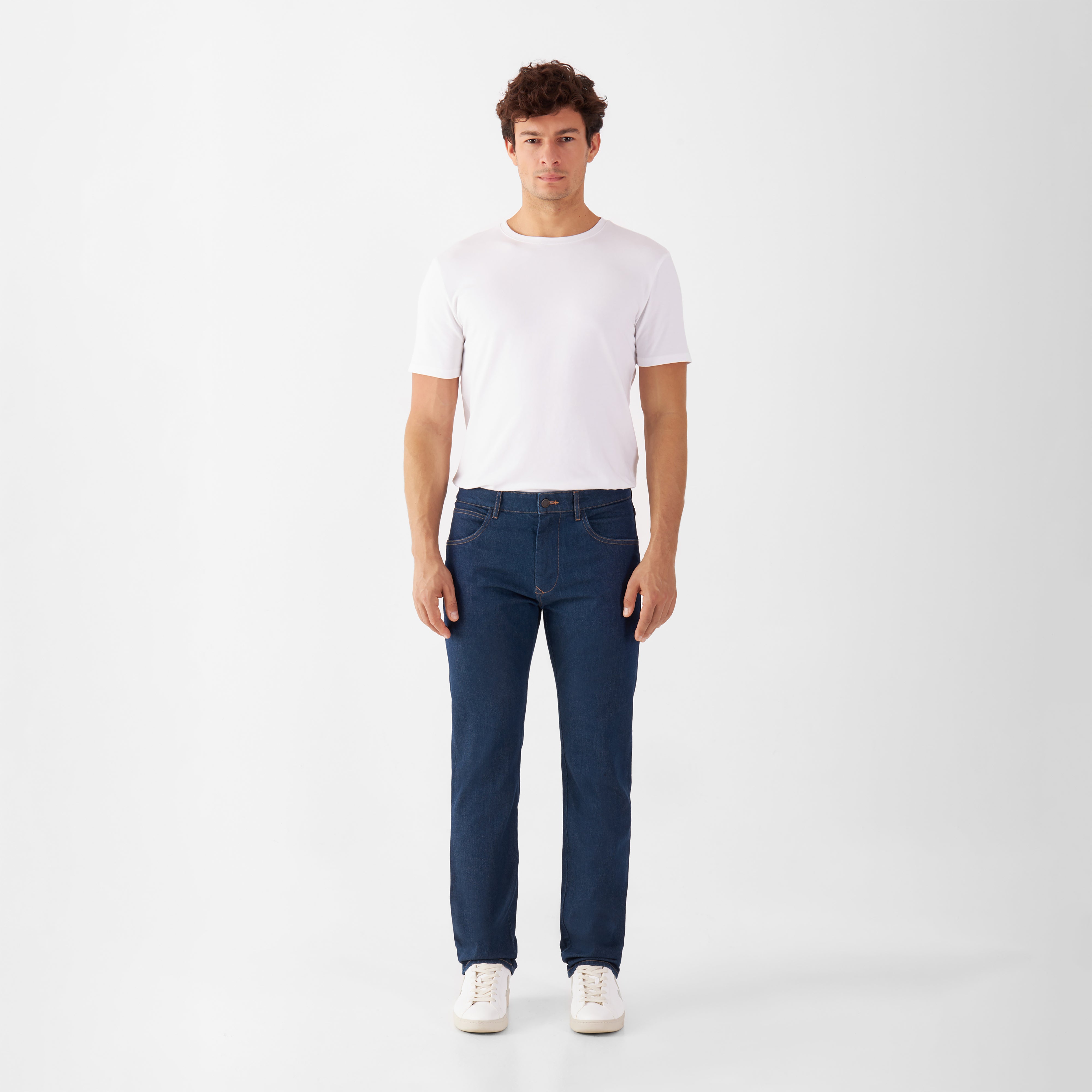 Frontansicht eines Mannes in weißem T‑Shirt mit klassischen blauen DUSK Jeans, Regular Slim Fit, mid-rise, gerades Bein.