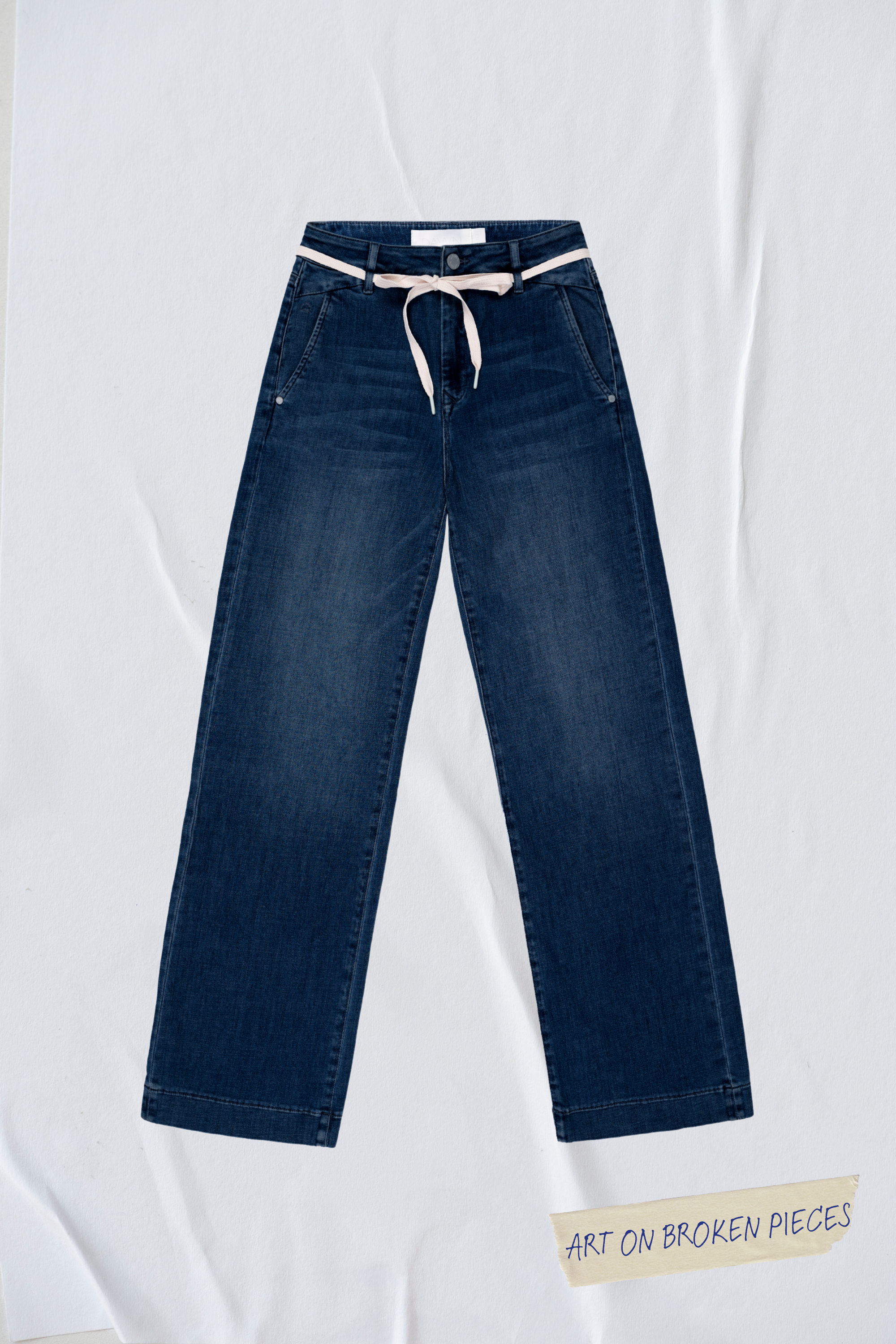 Dunkelblaue DEW Cropped Flared Jeans mit französischen Taschen, hohem Bund und hellem Gürtel; Art on Broken Pieces-Label