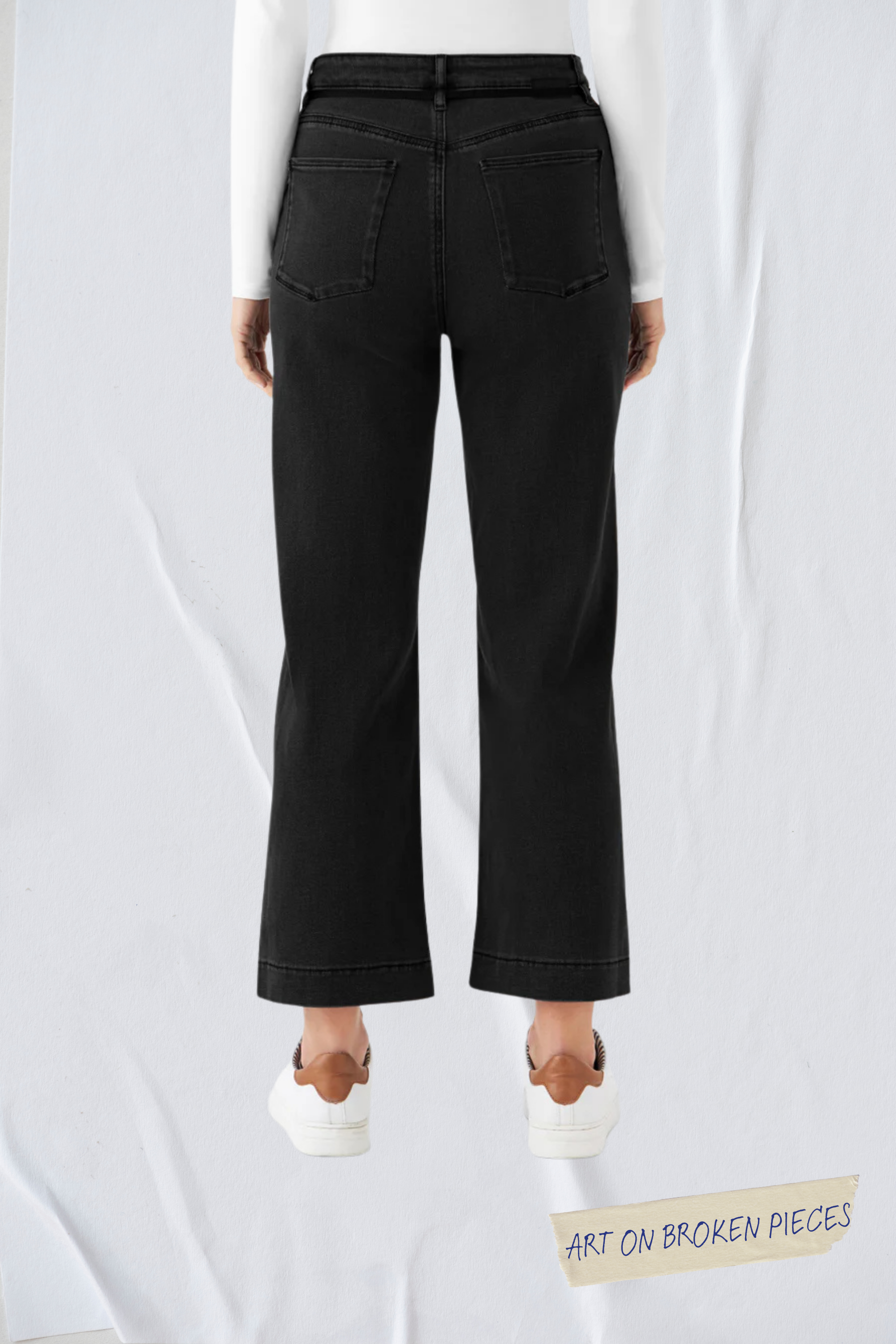 Rückenansicht einer schwarzen DEW Cropped Flared Jeans: hoher Bund, französische Taschen, weit auslaufendes Bein.