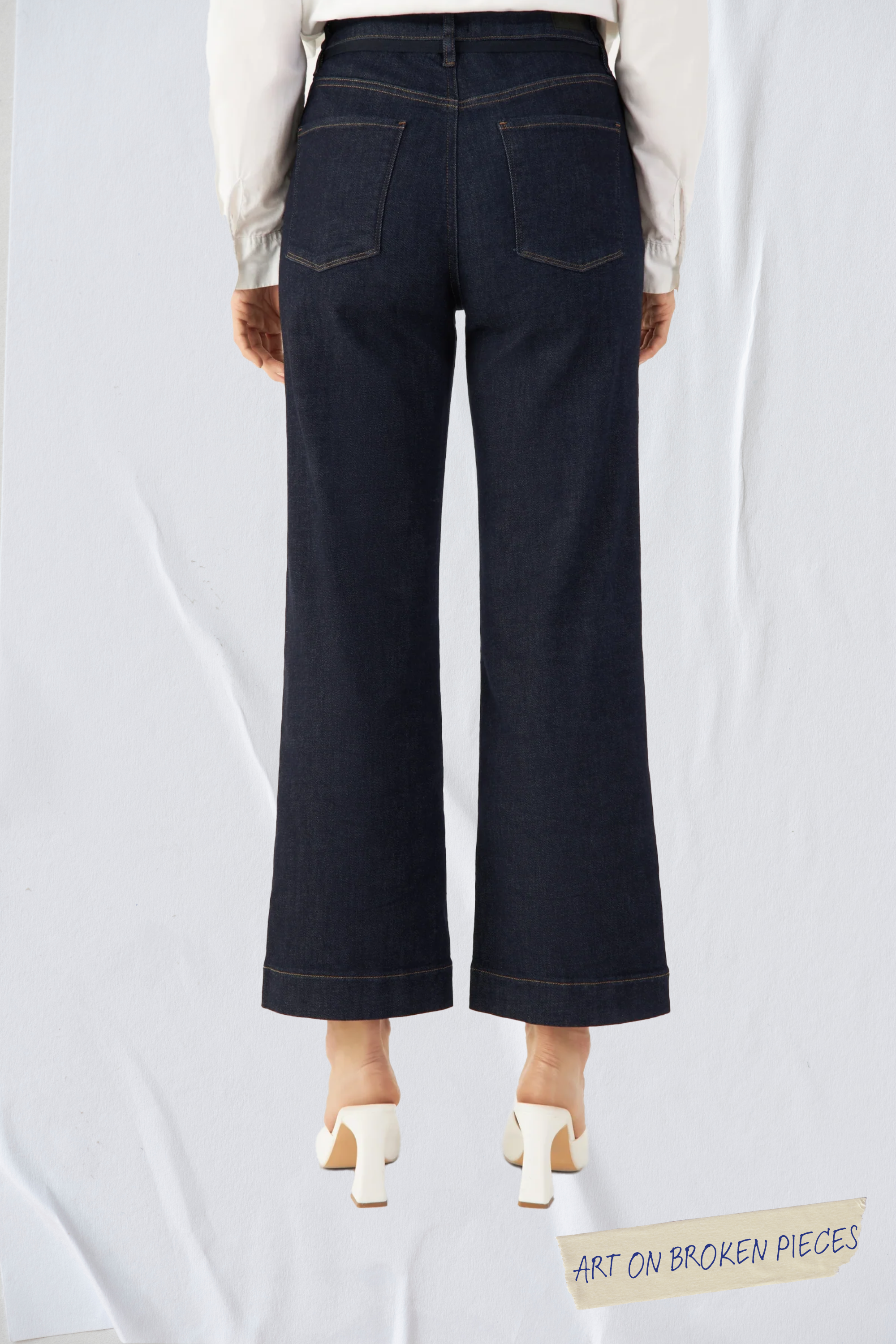 DEW Cropped Flared Denim in Raw Blue, hohe Taille, ausgestelltes Bein, Rückansicht mit zwei Gesäßtaschen – Art on Broken Pieces Edition.