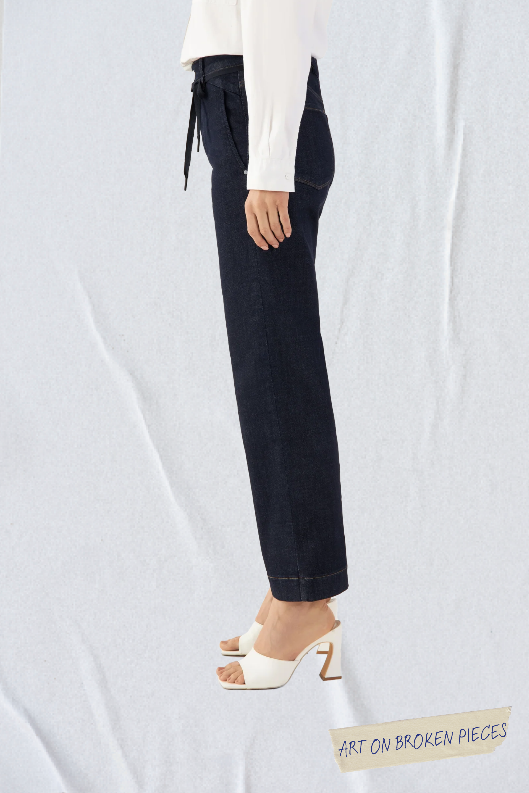 DEW Flared Cropped Soft Denim in Raw Blue – hohe Taille, ausgestelltes Bein, französische Taschen; Seitenansicht der Jeans am Model.