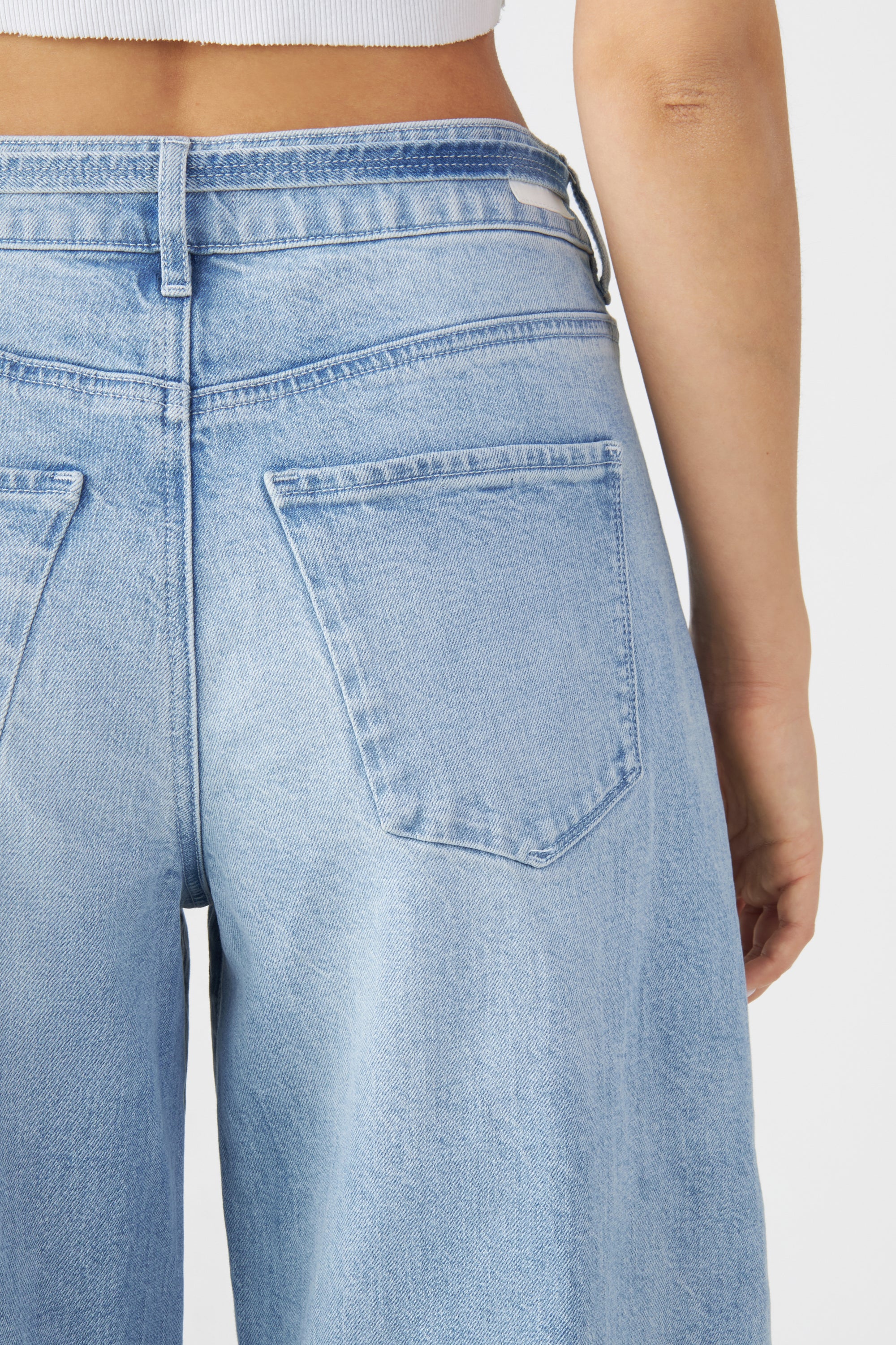 Rückansicht einer hellblauen SUNNY Wide-Leg-Jeans mit mittelhohem Bund, zwei Gesäßtaschen und Gürtel-Schlaufen; weites, gerades Bein.