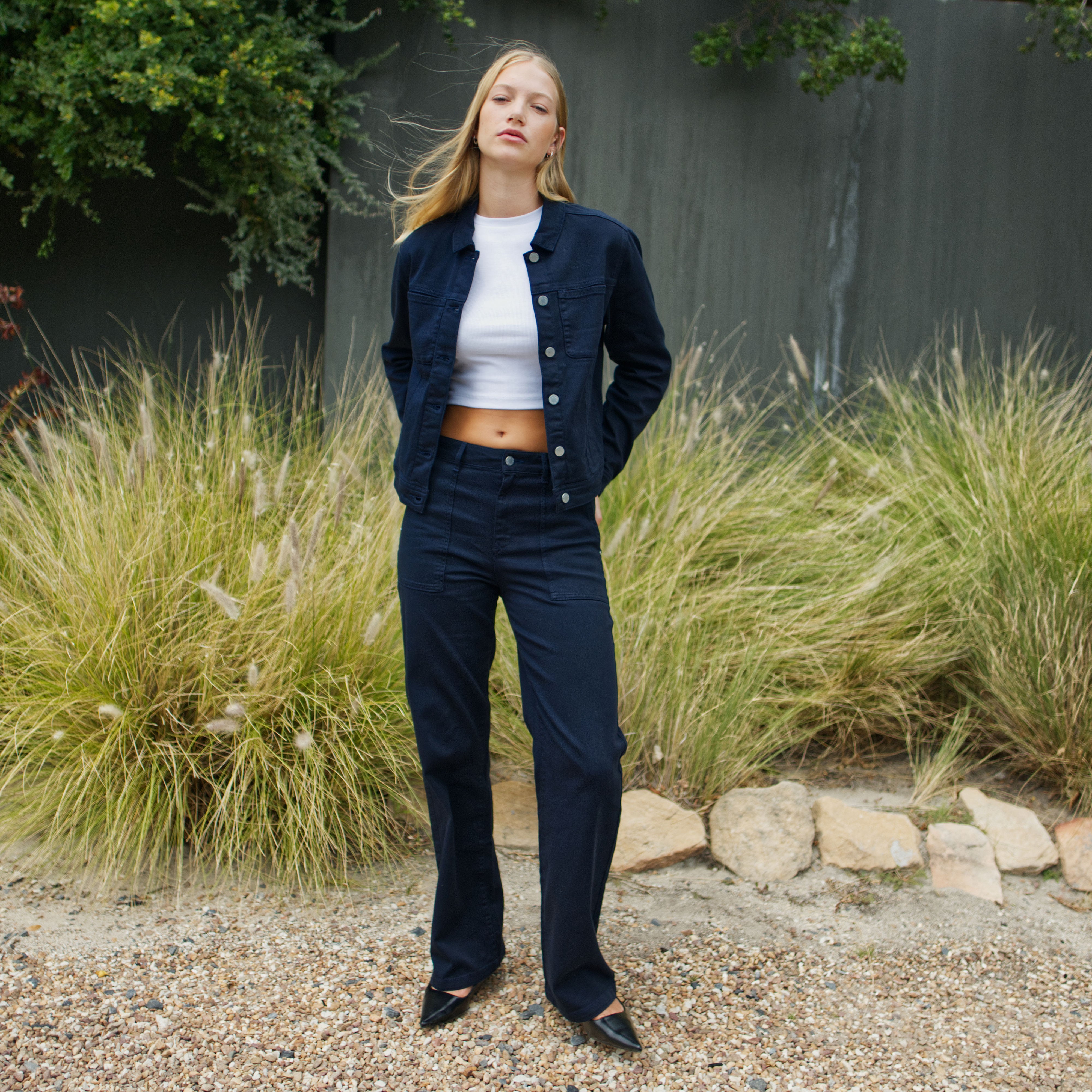 Modell in Nightsky Navy: DEW Flared Soft Denim Worker Jeans mit High-Waist, weitem Bein und großen Taschen.