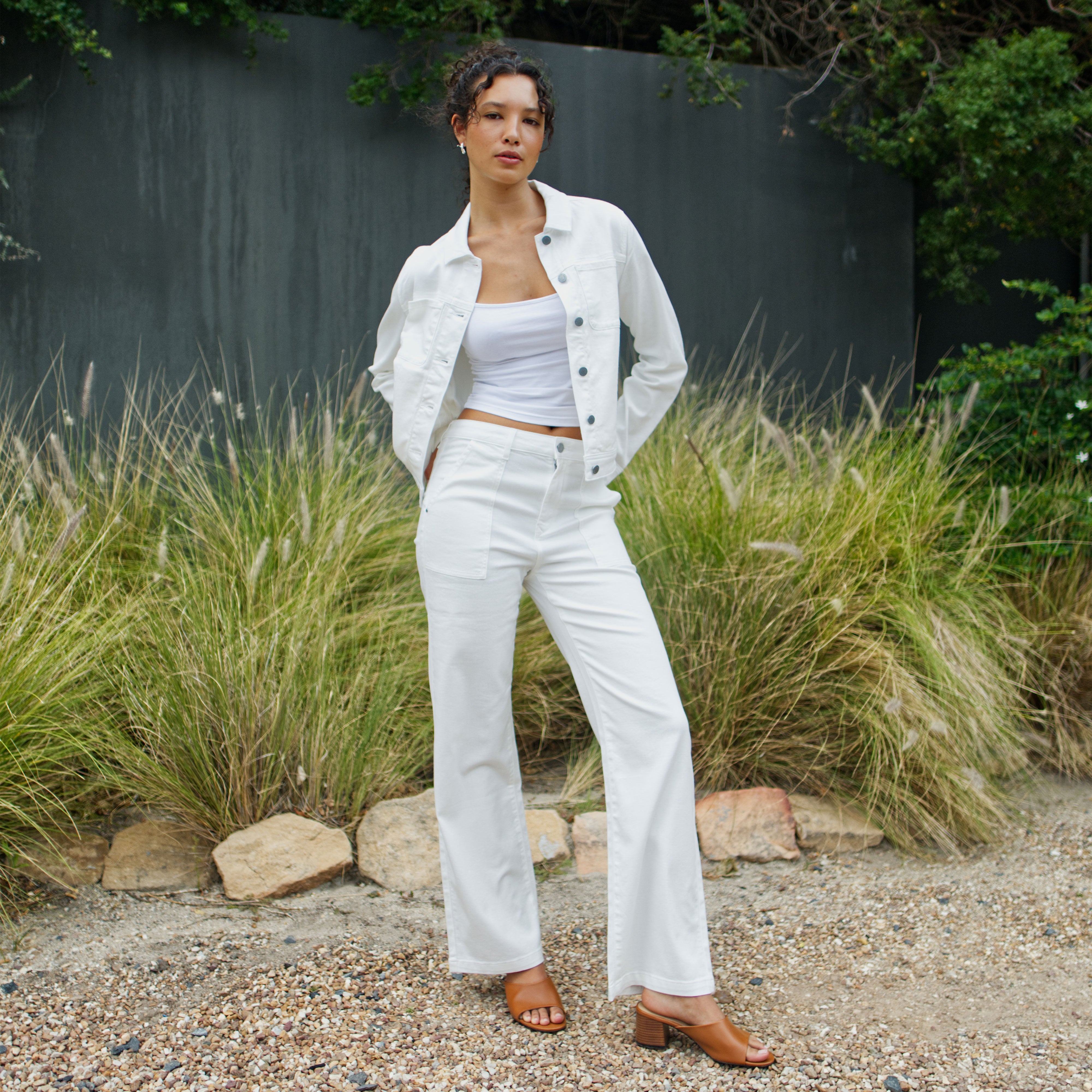 Weiße DEW Worker High-Waist Jeans mit weitem Bein und großen Taschen aus Organic Soft Denim White; Teil eines weißen Denim-Outfits.
