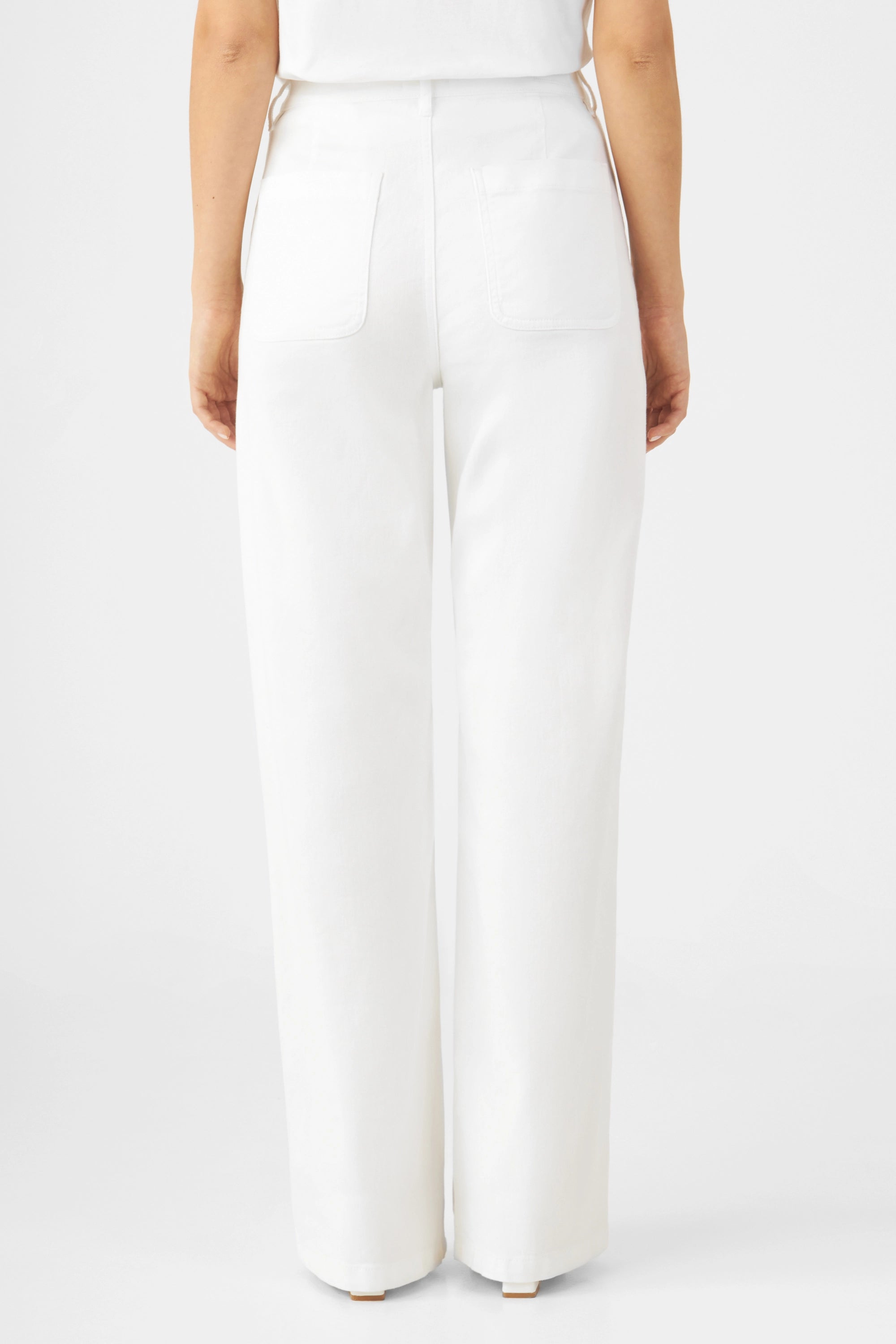 Weiße High-Waist Jeans mit weitem Bein, Rückansicht zeigt zwei aufgesetzte Gesäßtaschen im Worker-Stil.