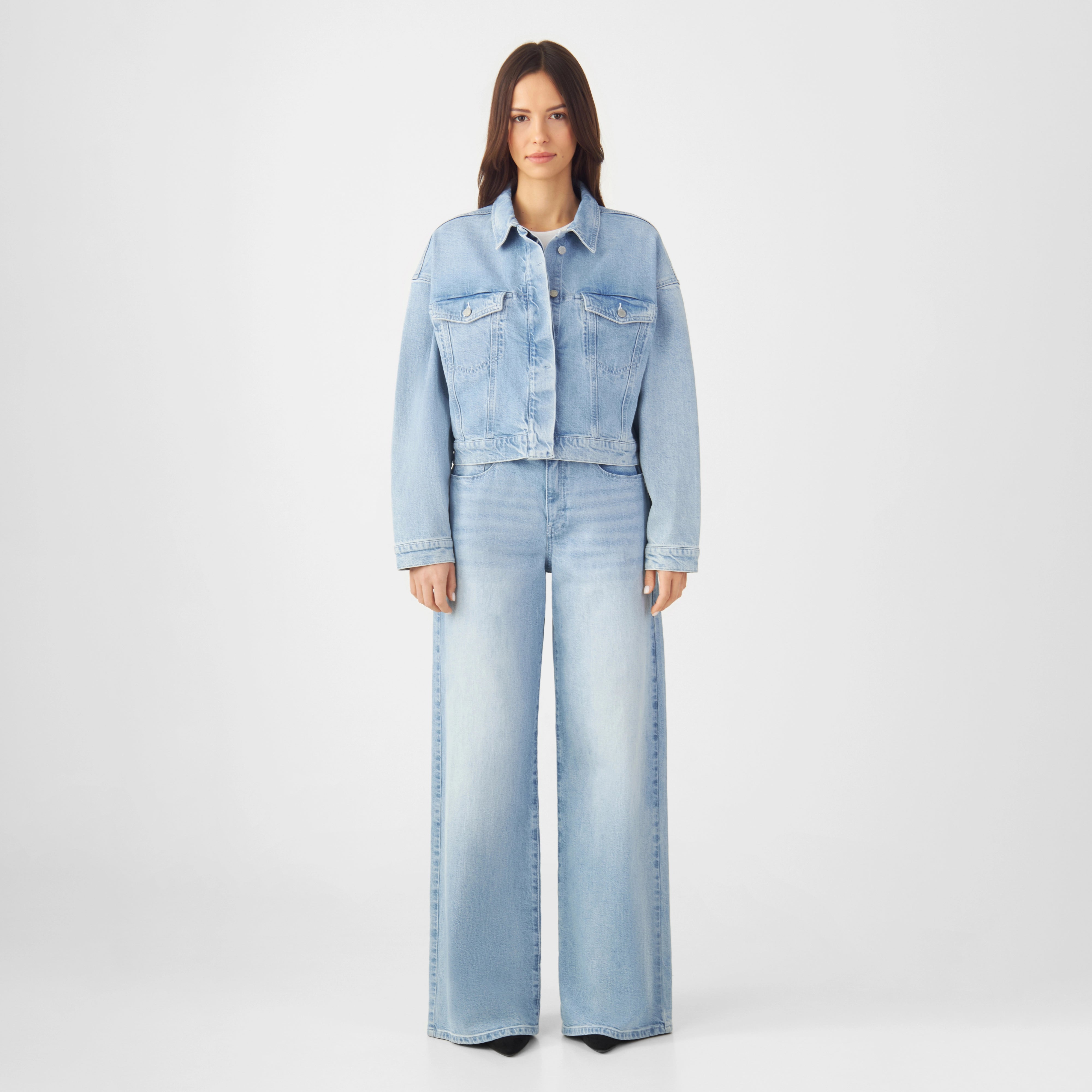 AMARA Boxy Denim-Jacke in Hellblau, kurze Silhouette, Brusttaschenklappen, verdeckte Knopfleiste, überschnittene Schultern.