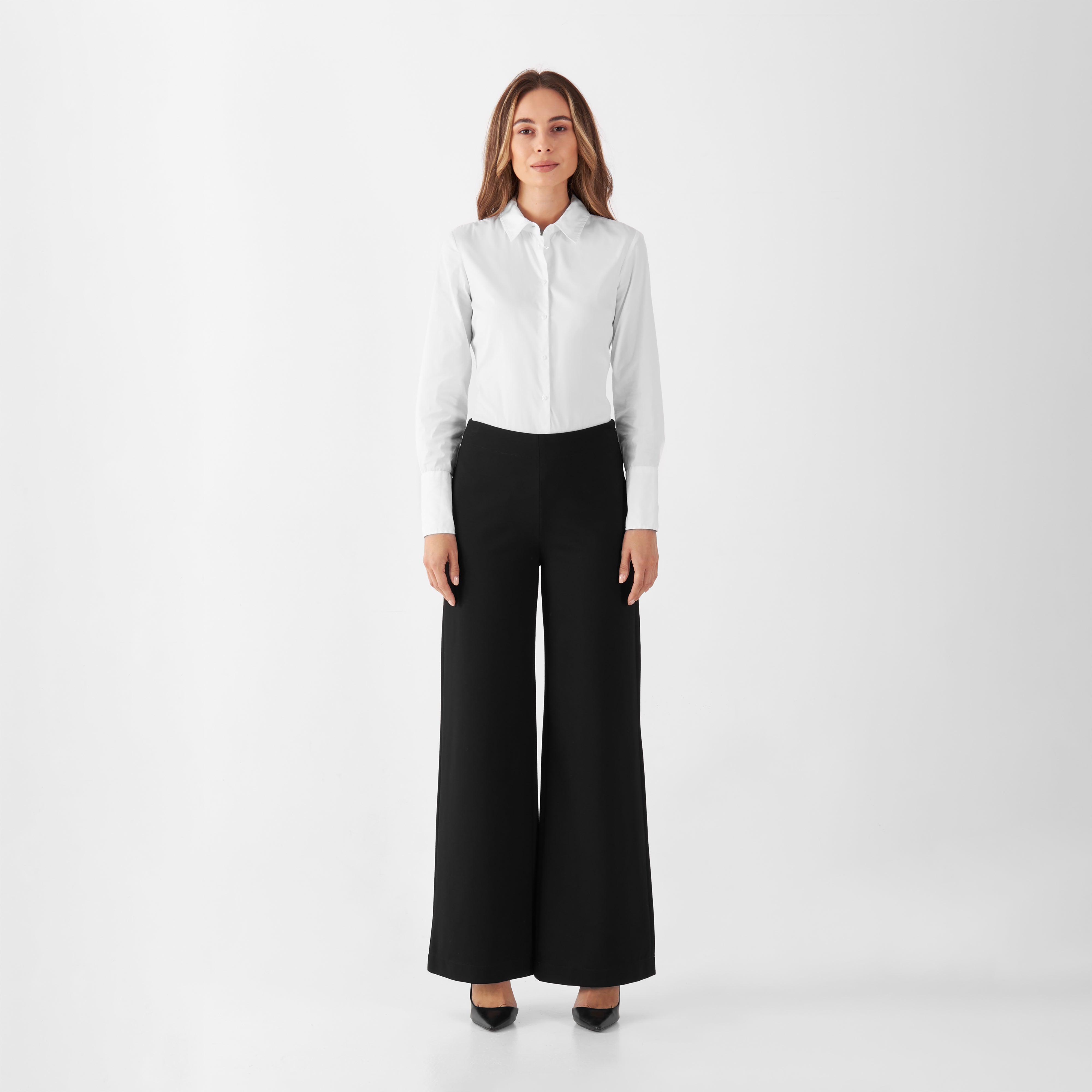 Schwarze GLOOM Wide-Leg-Hose von DAWN, hoch tailliert, weites Bein, seitlicher Reißverschluss; Modell trägt dazu ein weißes Hemd.