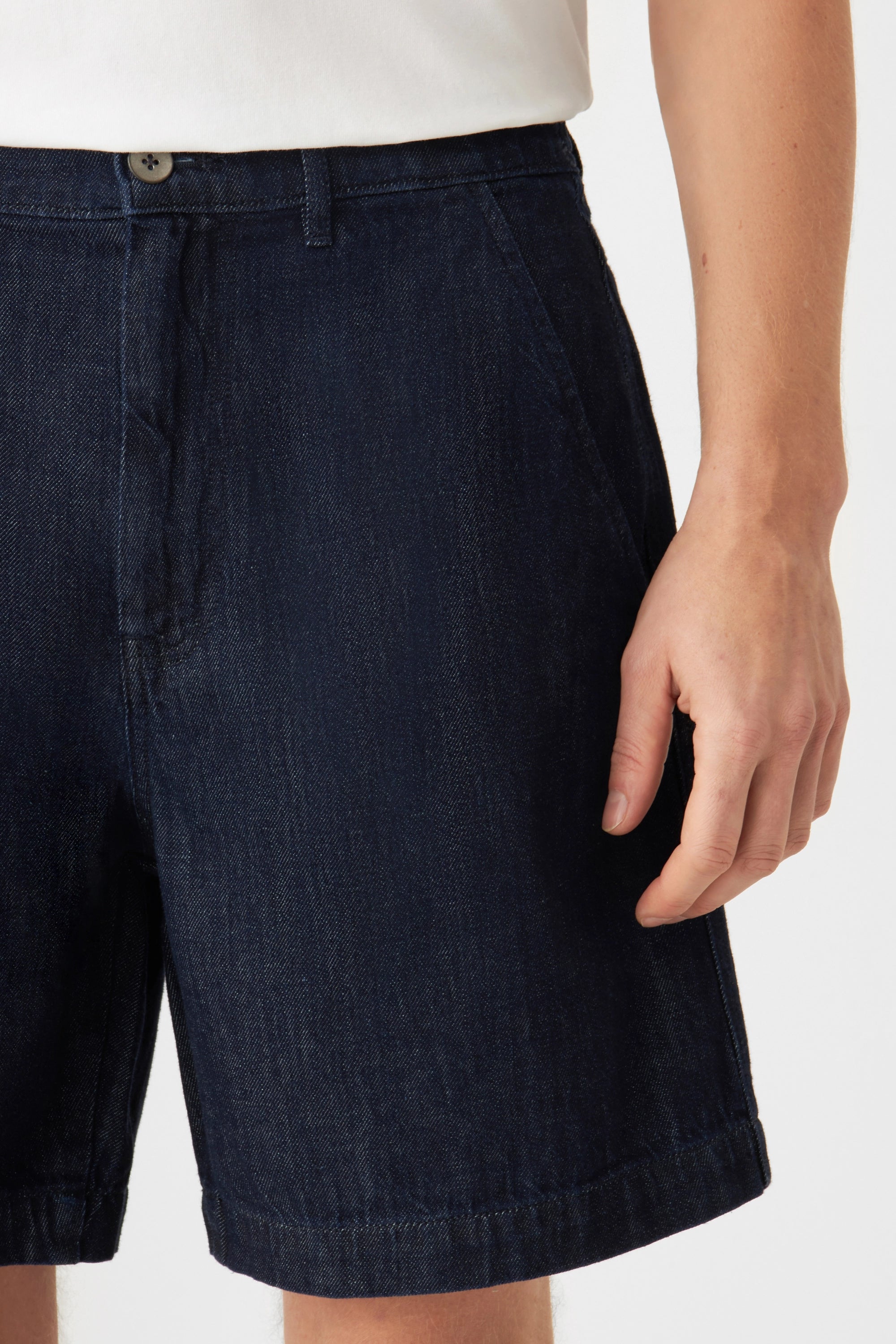 Raw Blue SHORTY Shorts mit mittlerer Taille und weiterem Schnitt aus dunklem Denim; vorne sichtbare französische Taschen.