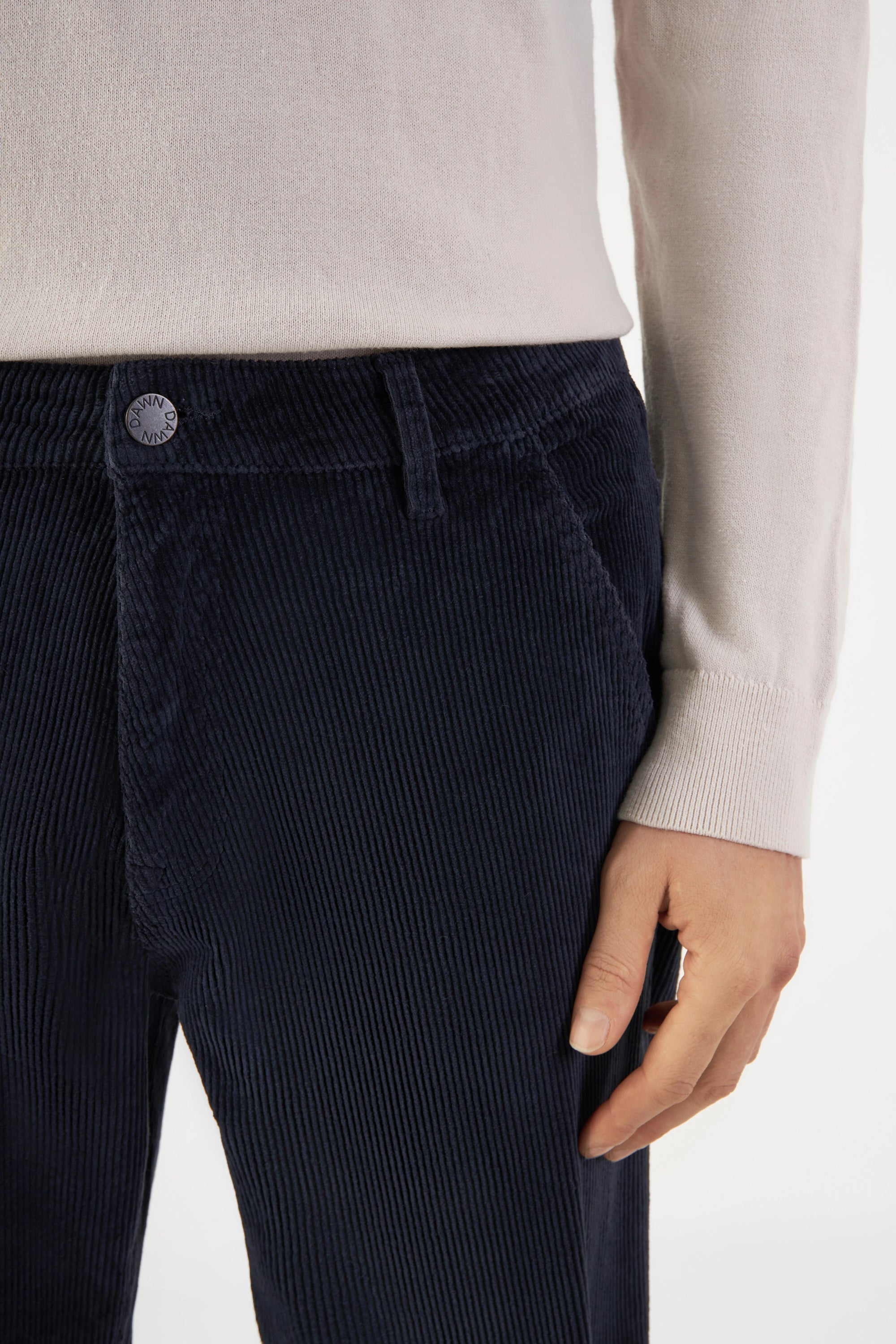 Dunkelblaue MANE Corduroy-Hose im entspannten Straight-Fit, mittelhoher Bund, schräge Fronttaschen; DAWN-Knopf am Bund.