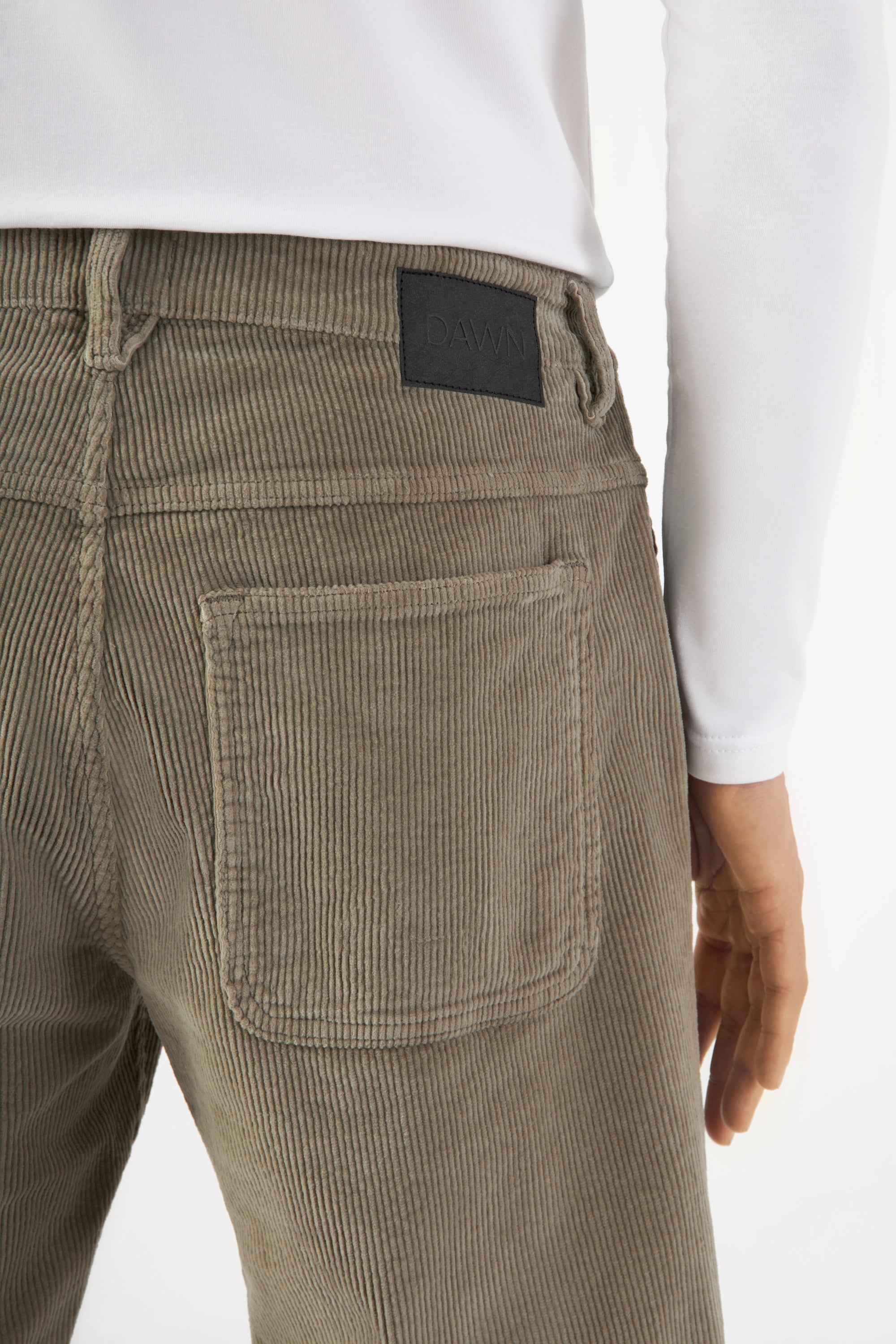 MANE Corduroy-Hose in Sage Green, relaxed straight; mittelhoher Bund, sichtbare Rückentasche, DAWN-Label am Bund.