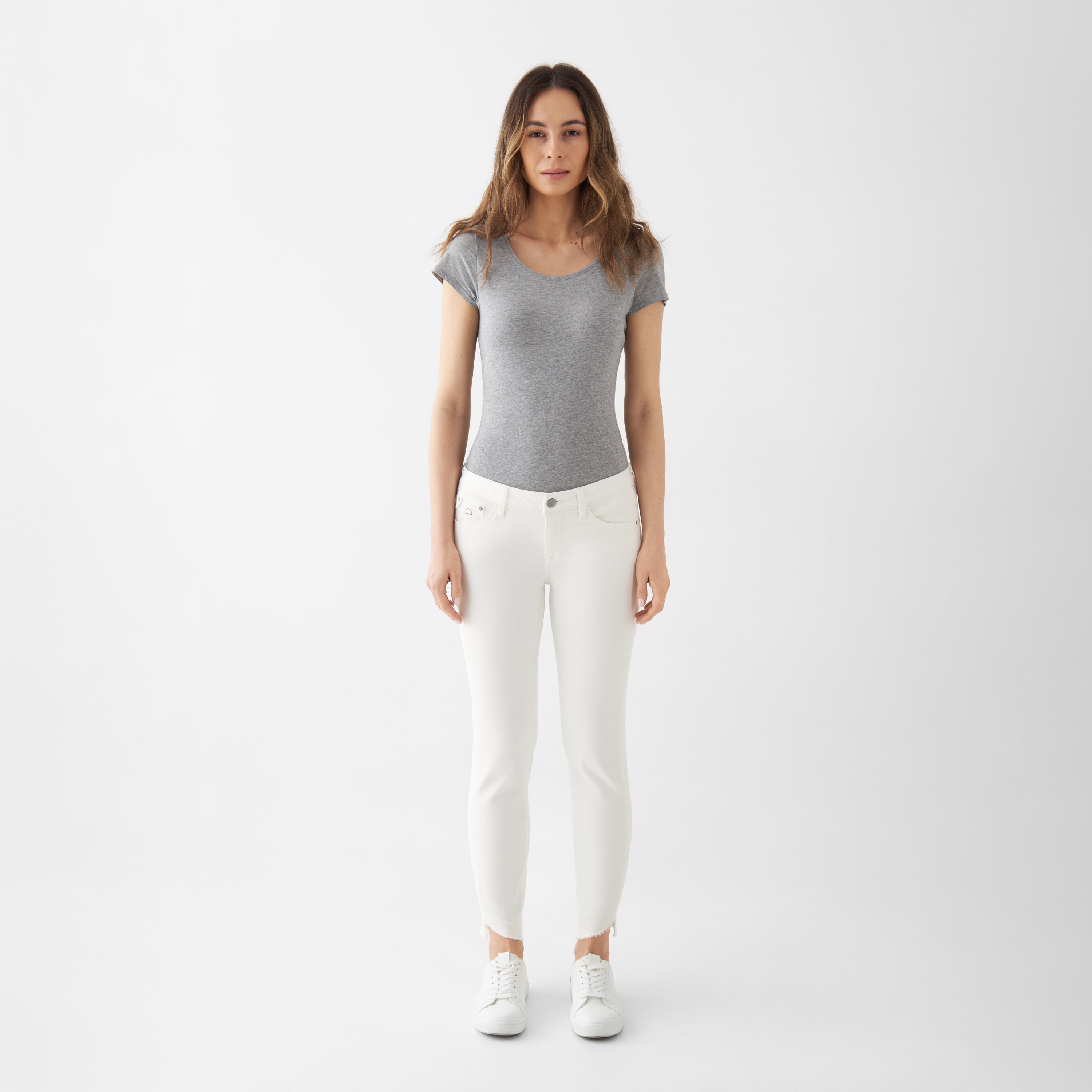 Weiße Slim‑Fit Jeans aus Organic Comfortstretch mit offenem, gefransetem Saum und klassischem 5‑Pocket‑Design (Low‑Waist).