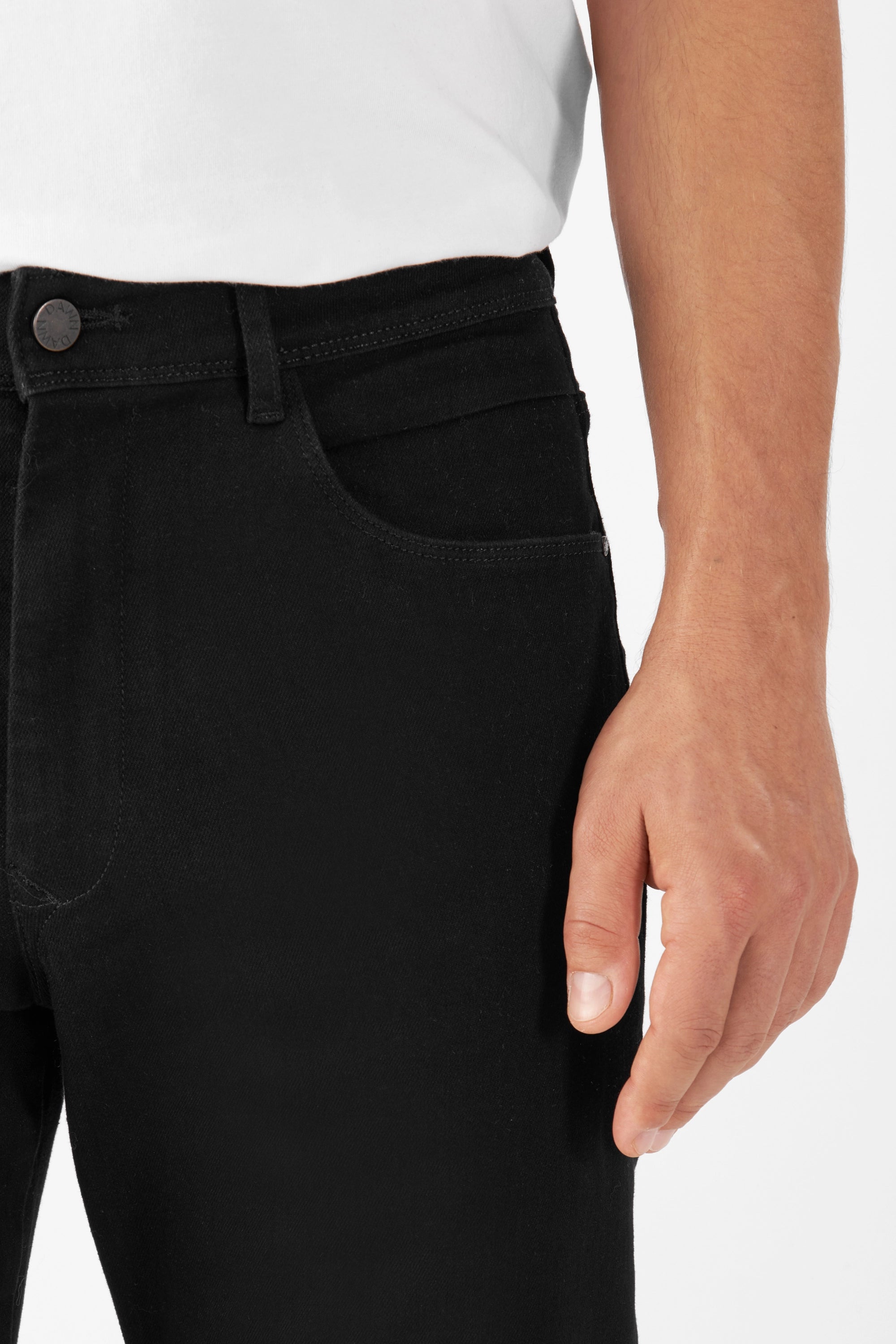 Schwarze MORROW Slim Fit Jeans mit mittlerer Taille; Nahaufnahme der Vorderseite mit Knopf und Fronttasche eines Modells.