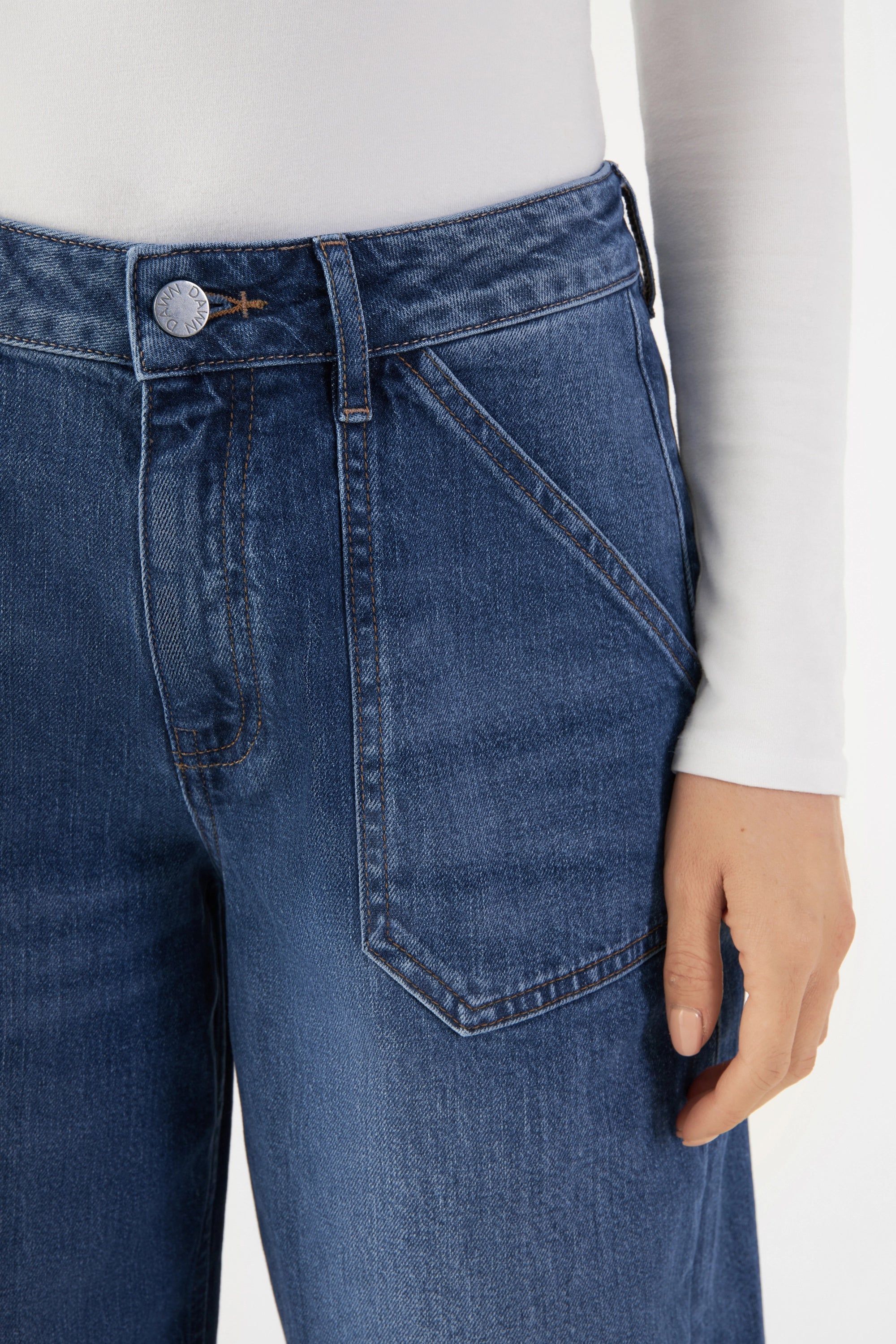 Sunny Worker Jeans in Medium Blue: mittelhoher Bund, weites gerades Bein; aufgesetzte Fronttaschen im Worker-Stil, Metallknopf sichtbar.