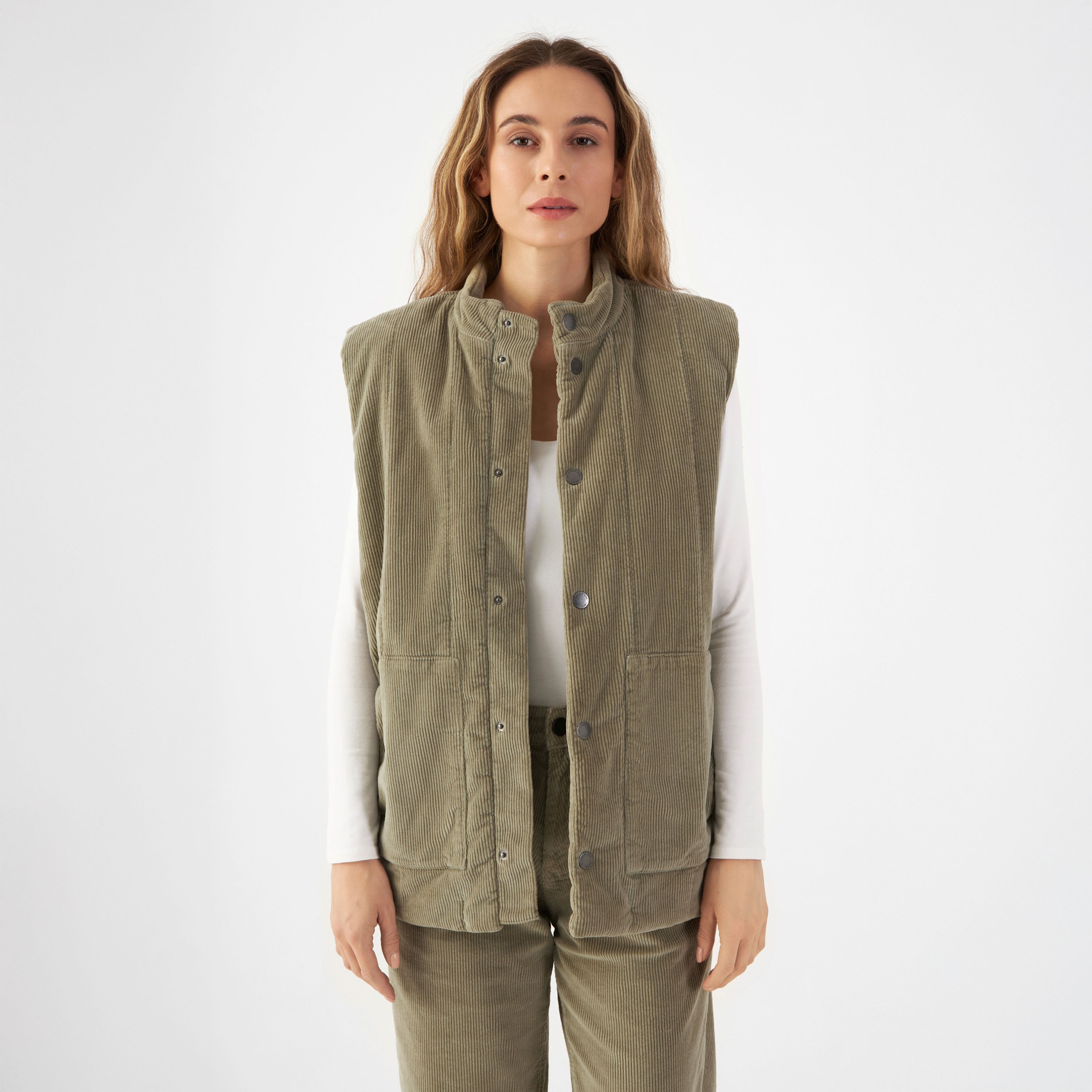 Sagegrüne wattierte Corduroy-Weste im Utility-Stil, vertikale Steppung; boxy-Schnitt endet knapp über der Hüfte, Taschen.