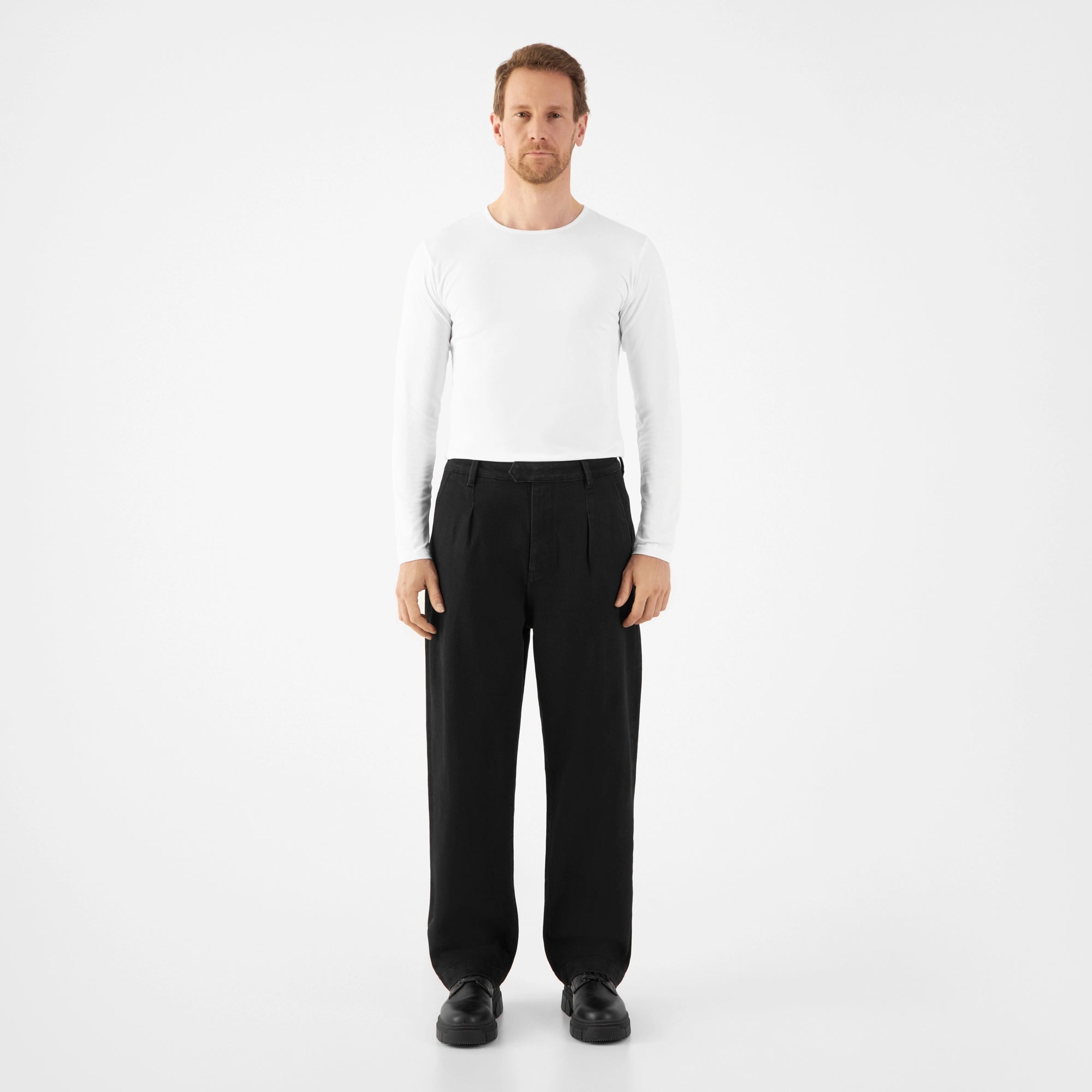 Moderne schwarze Balloon-Fit Hose ASTER aus TENCEL-Denim, mittelhoher Bund, weite Hüften/Oberschenkel, verengt sich zum Saum (Frontansicht).