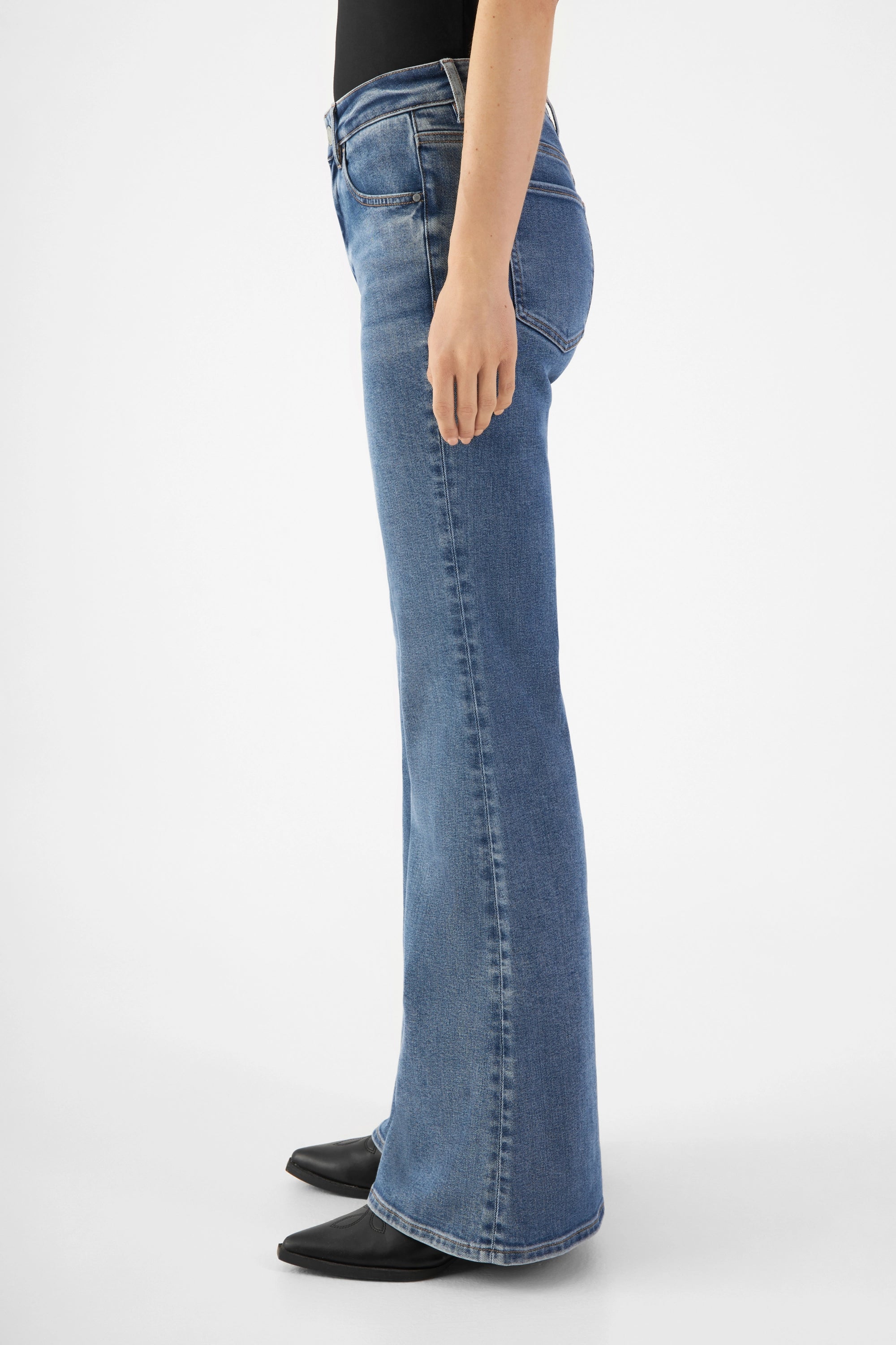 CELESTIAL Slim Flared Jeans in Medium Blue, mittelhoher Bund, schmal bis Knie, ab Knie stark ausgestelltes Bein – Seitenansicht.