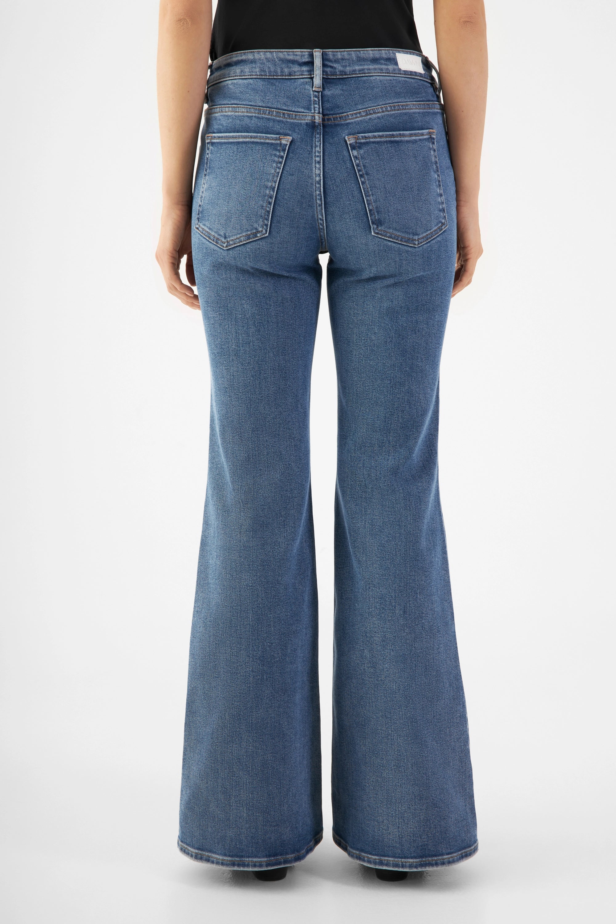 Rückansicht der mittelblauen CELESTIAL Jeans mit mittelhohem Bund; eng bis übers Knie, danach stark ausgestelltes Bein, zwei Gesäßtaschen.