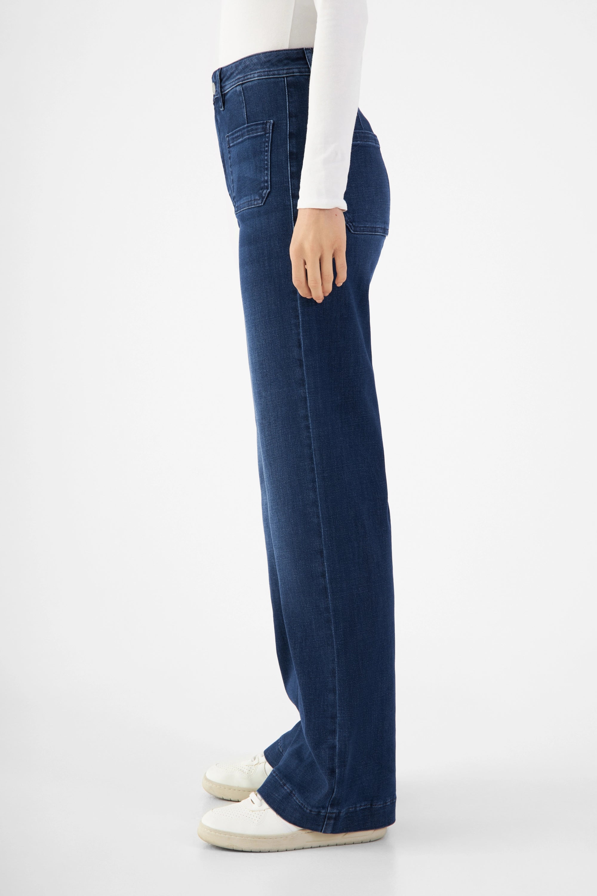 Seitenansicht einer dunkelblauen DEW Sailor High-Waist-Flare-Jeans aus Organic Soft Denim mit aufgesetzten Taschen vorne und hinten.