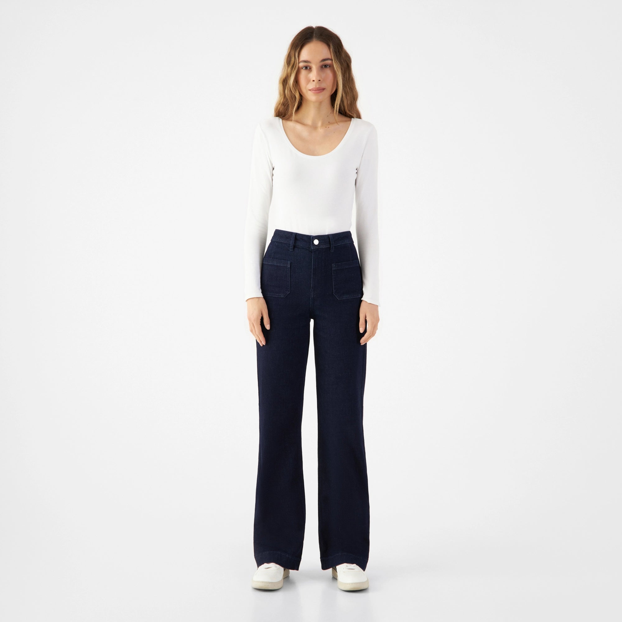 DEW Sailor: Hoch taillierte, flared Denim-Jeans in Raw Blue aus Organic Soft Denim, vorne mit aufgesetzten Taschen.