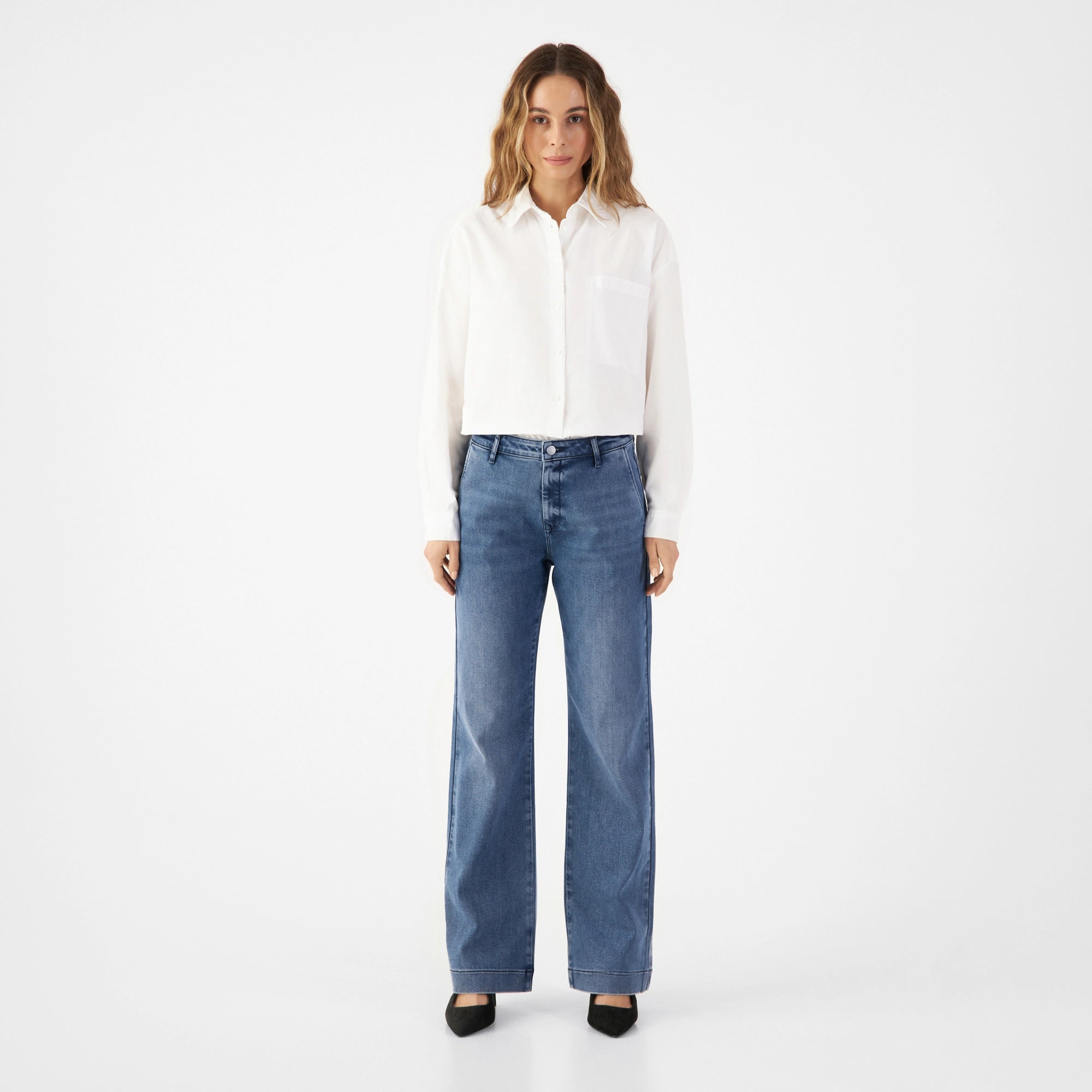 GLOW Denim-Chino in Medium Blue, mittelhohe Taille, ausgestelltes Bein; französische Taschen vorne, Paspeltaschen hinten.