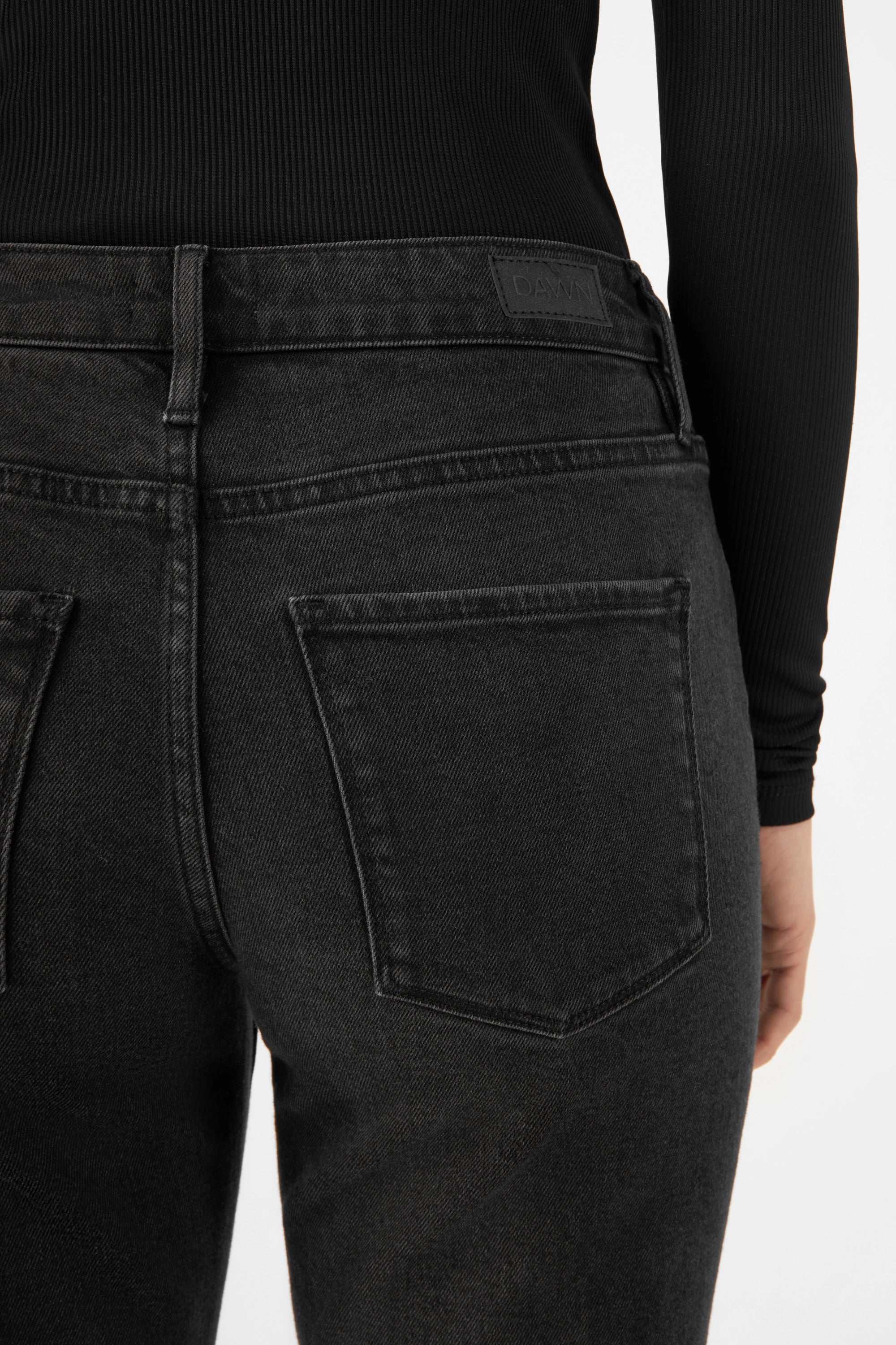 Rückansicht der Vintage-Black SUNSET Jeans von DAWN – schlank geschnitten, mittelhoher Bund, zwei Gesäßtaschen, dunkle Waschung aus TENCEL-Denim.